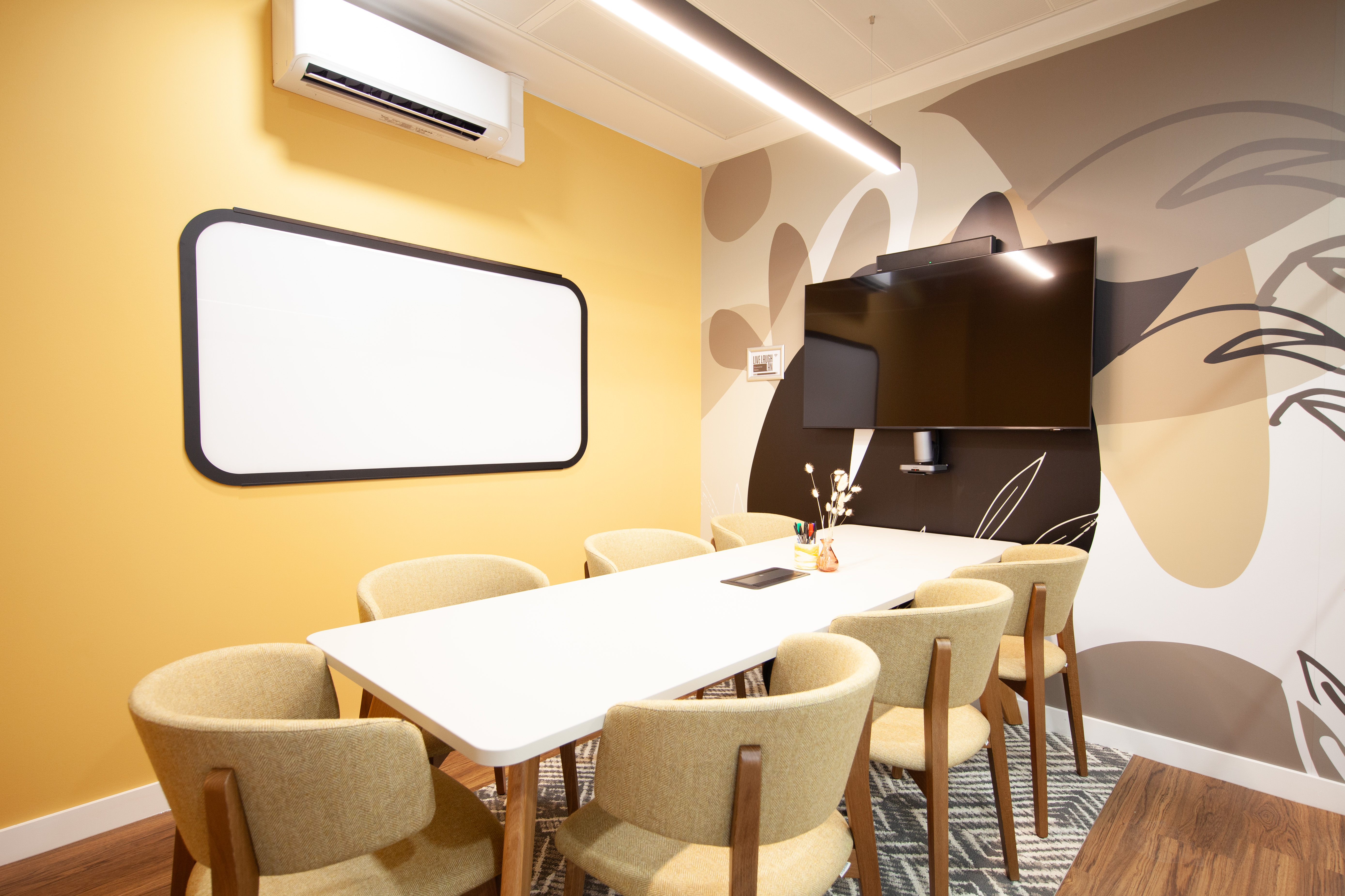Modern meeting room with yellow accent wall for collaborative events at Runway East Bloomsbury.