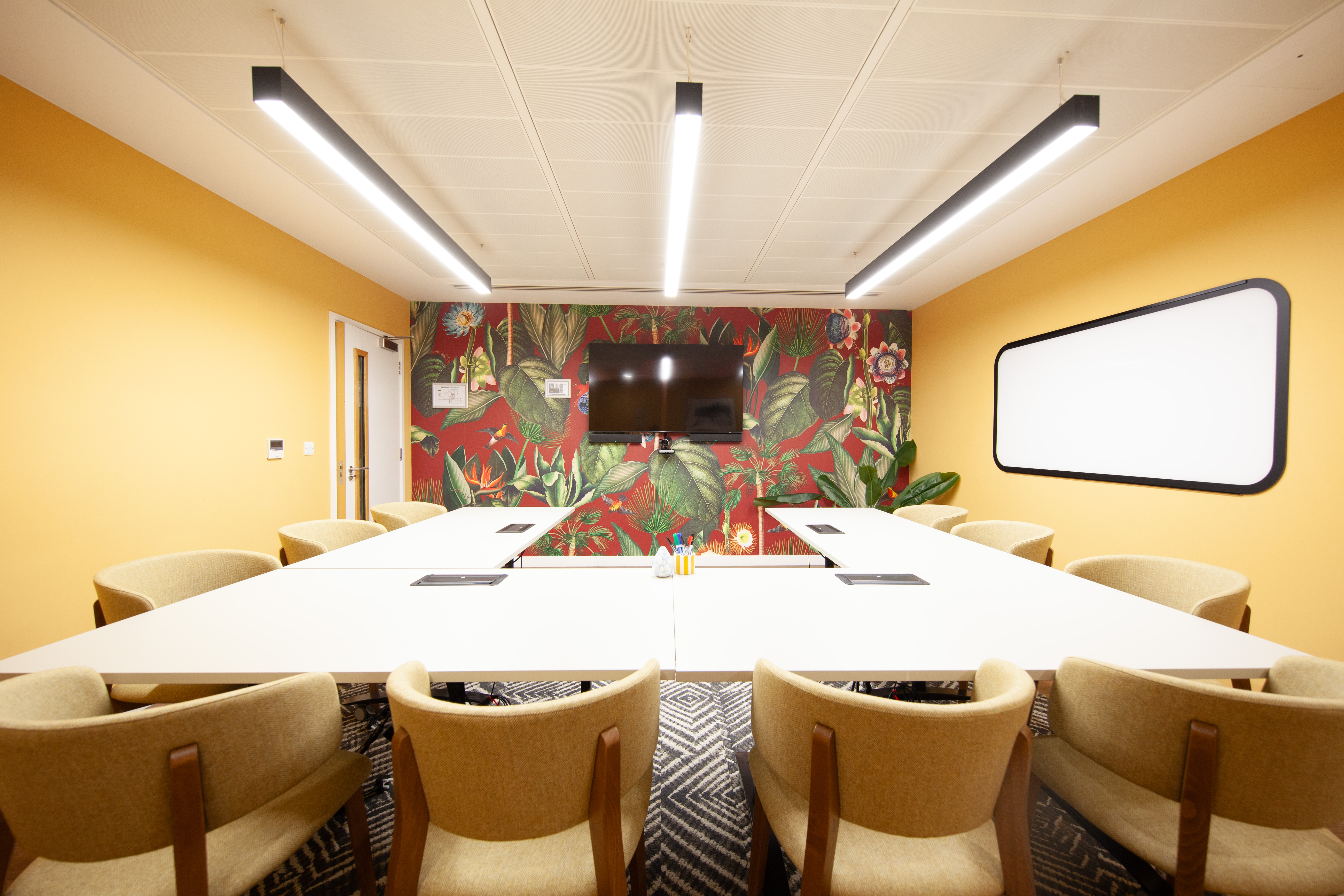 Vibrant meeting room with orange walls for creative brainstorming at Runway East Bloomsbury.