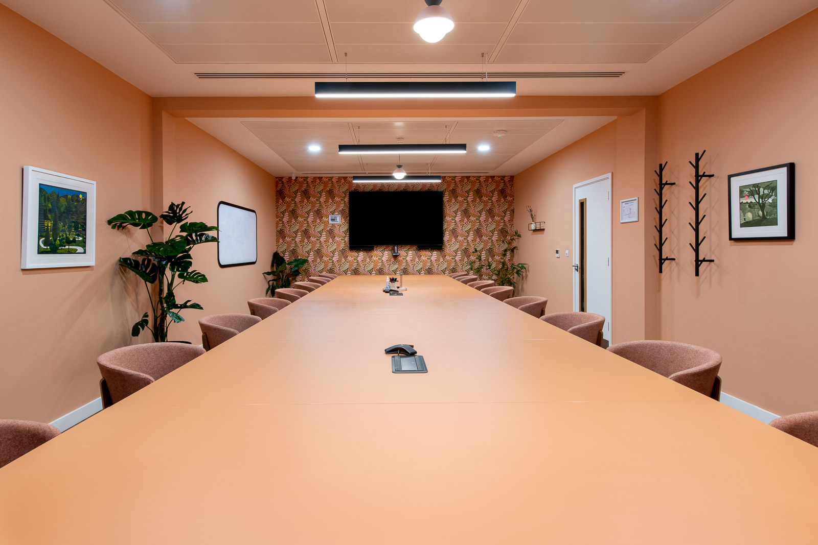 Modern meeting room with orange table, ideal for collaborative events and presentations.