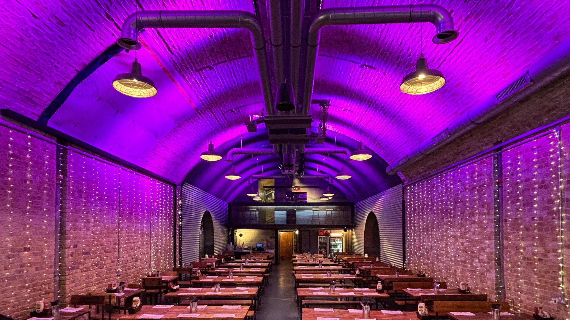 The Old Arch restaurant with vibrant purple lighting, ideal for corporate events and celebrations.