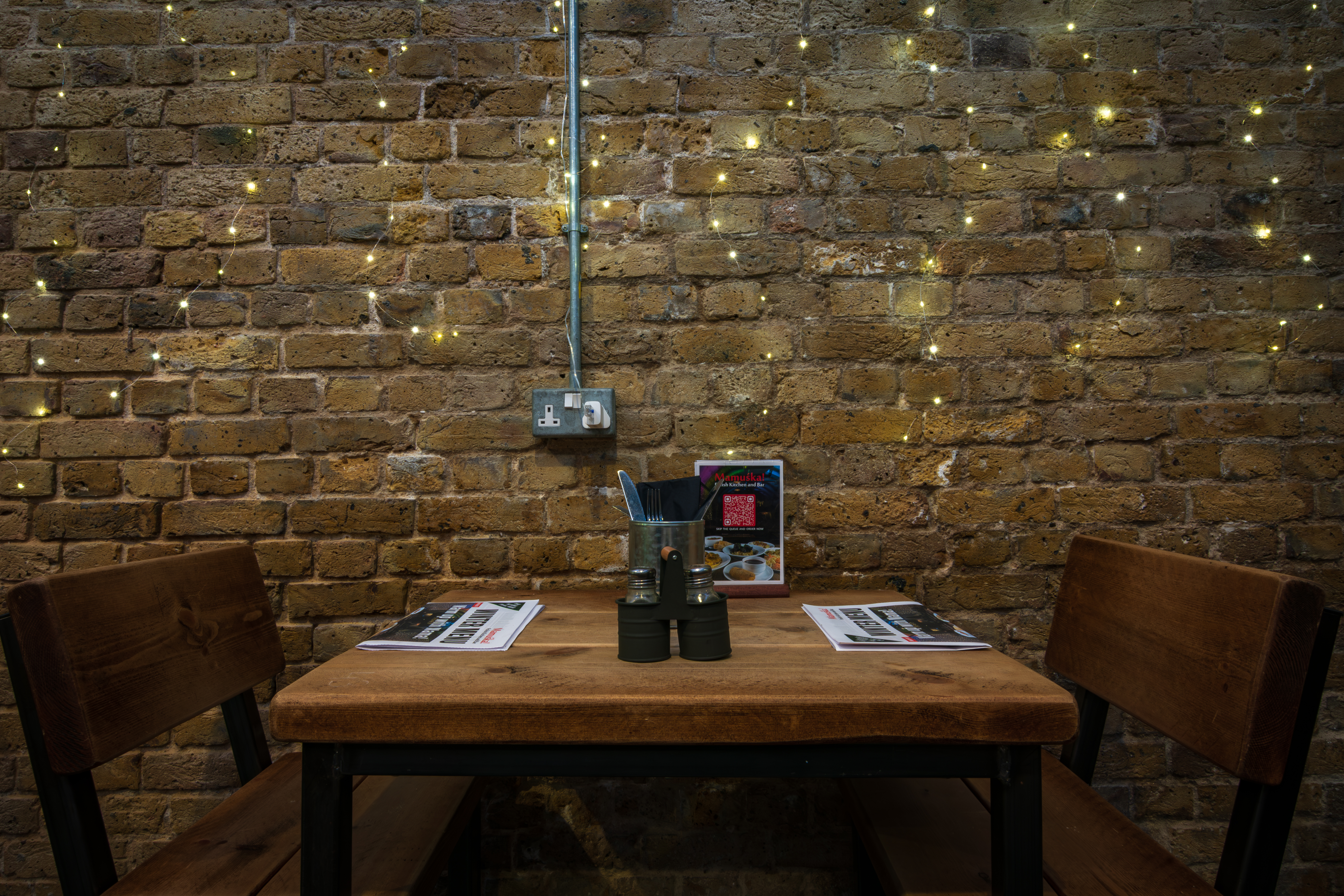 Cozy meeting space with rustic table; ideal for casual gatherings at Mamuśka Restaurant.