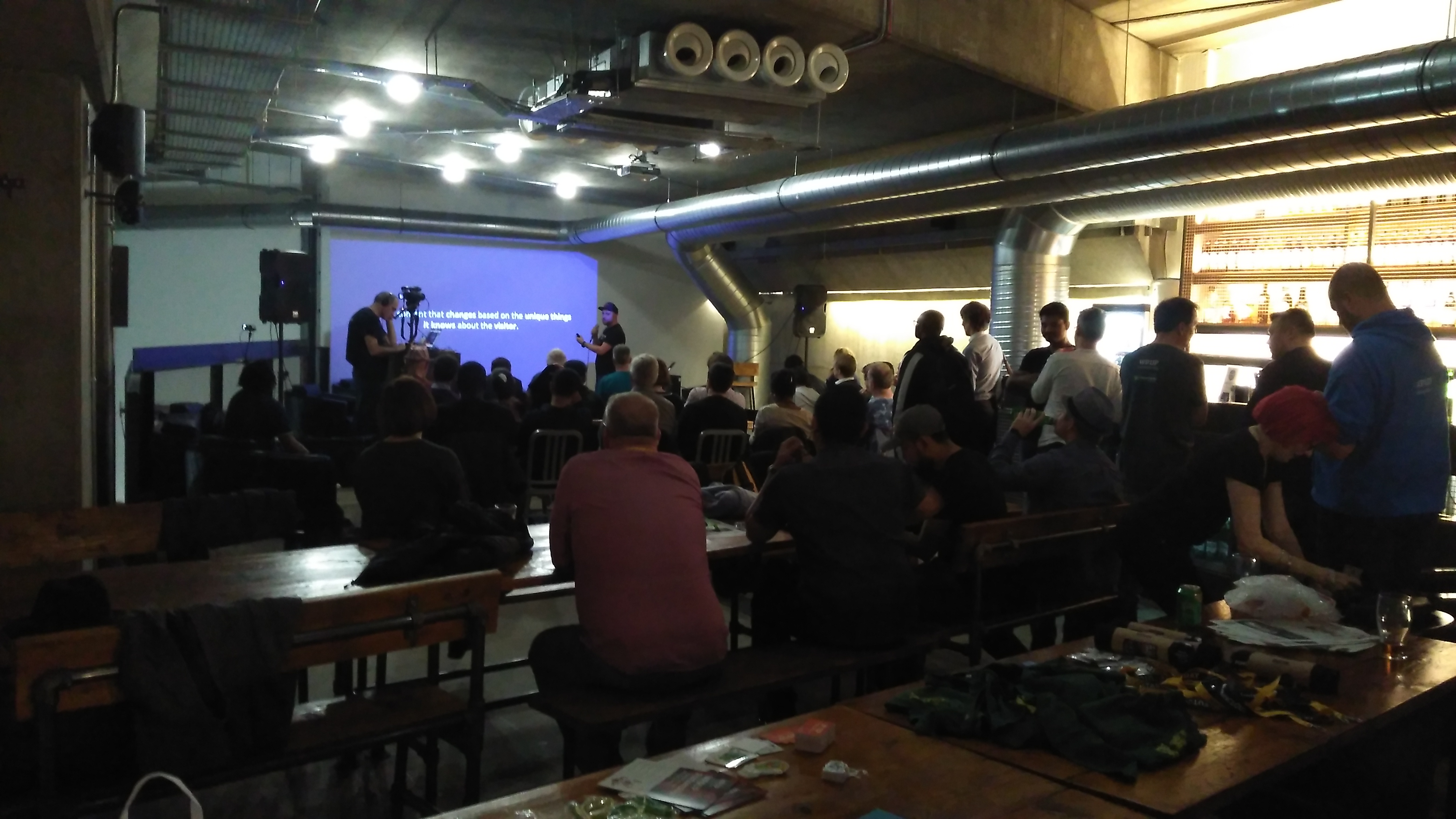 Lively event at Mamuśka! Restaurant with communal tables and presentation setup.