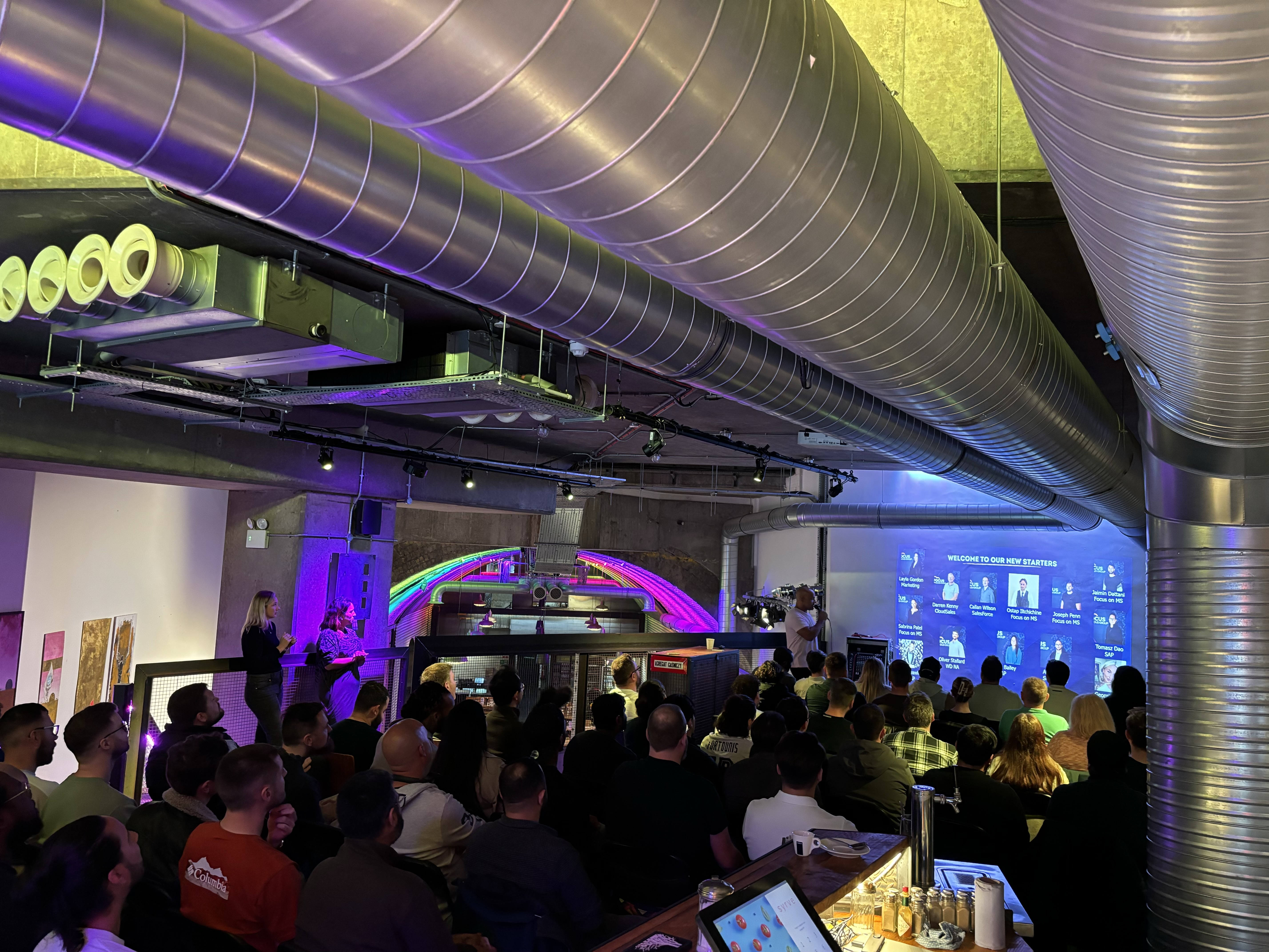 Dynamic event at Mamuśka! Restaurant & Bar with colorful lighting and industrial decor.