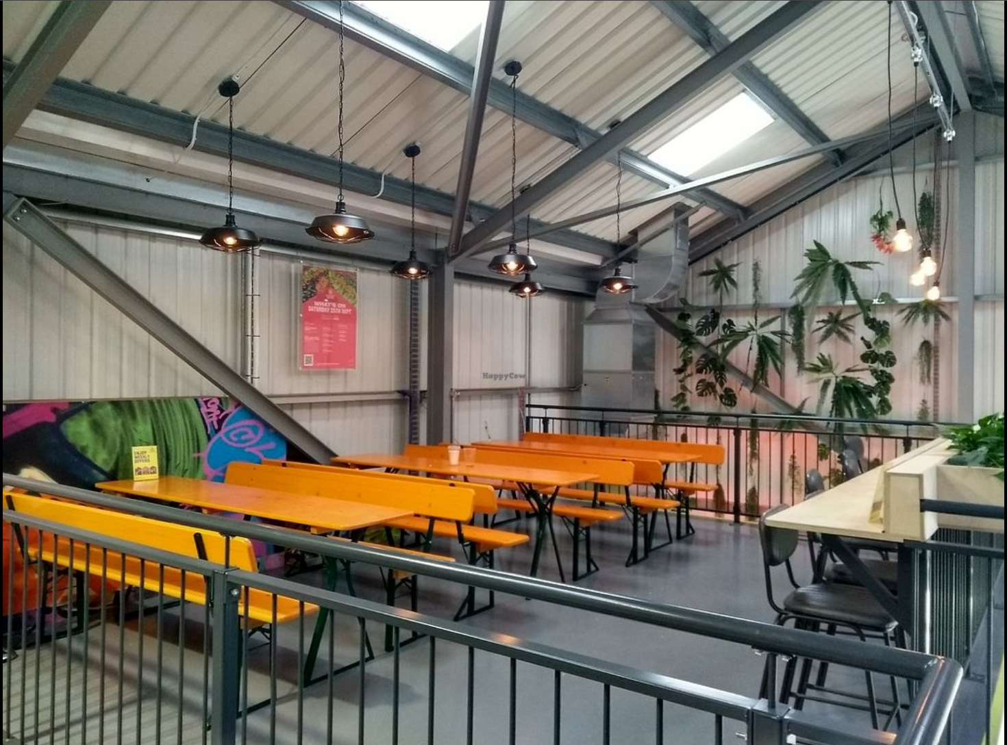Versatile event space in Hackney Bridge with orange tables for networking and workshops.