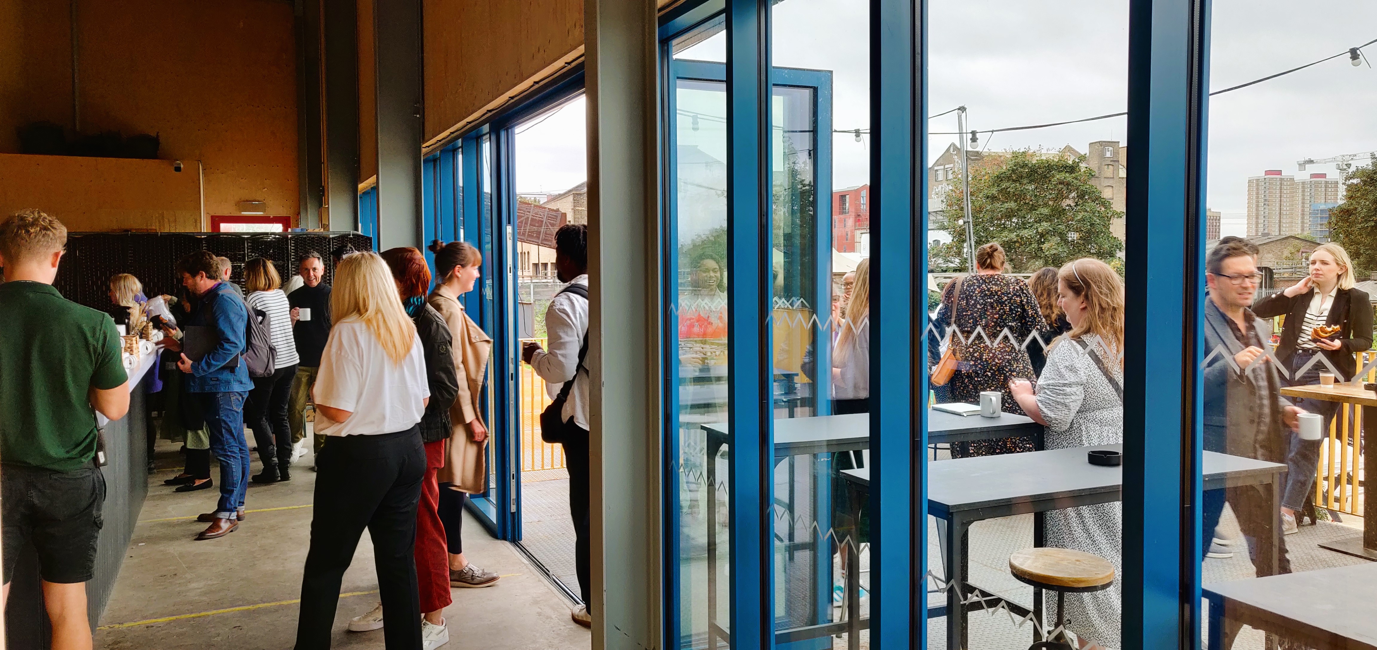 Vibrant networking event at Hackney Bridge with natural light and casual seating.