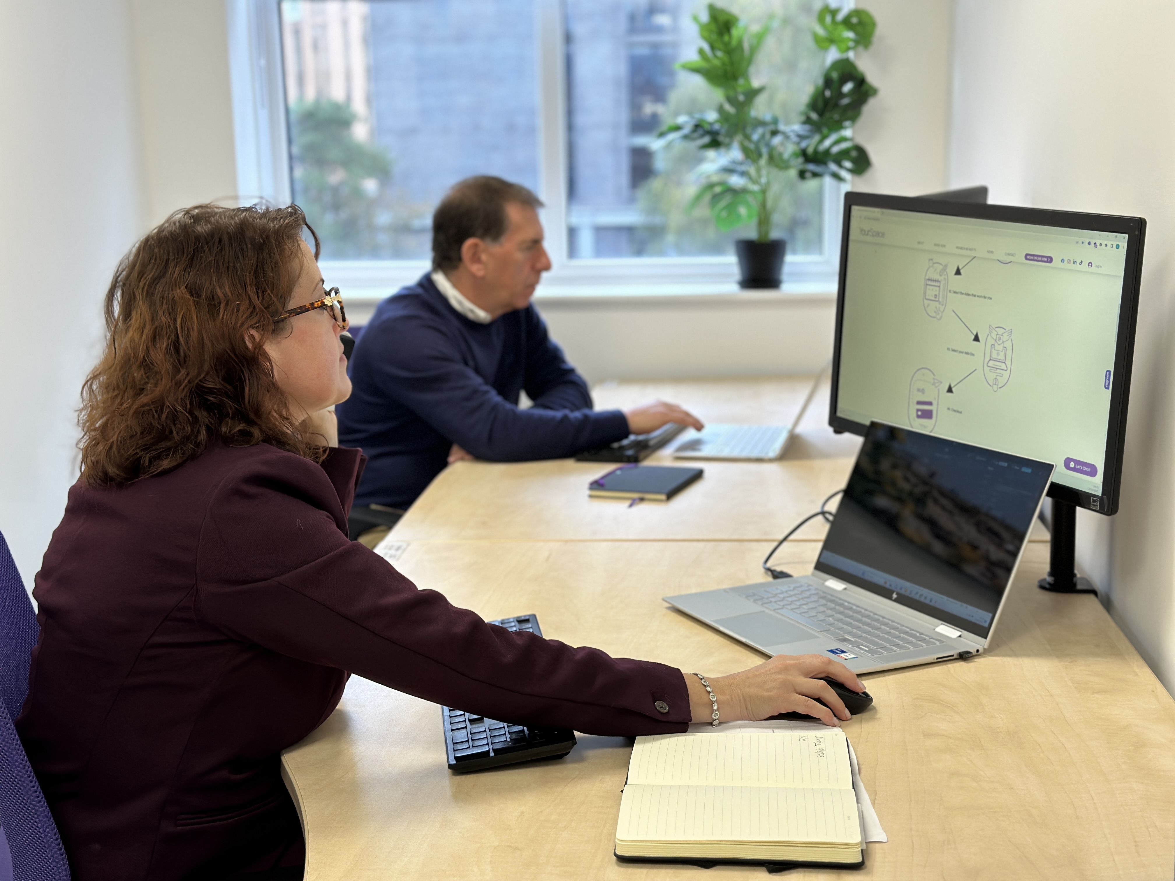 Collaborative workspace with professionals in virtual meeting, modern tech environment.