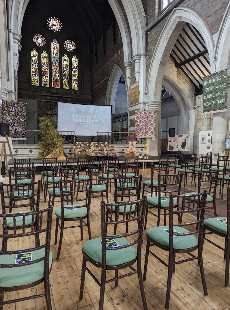 Event space with stage and screen, ideal for presentations and discussions.