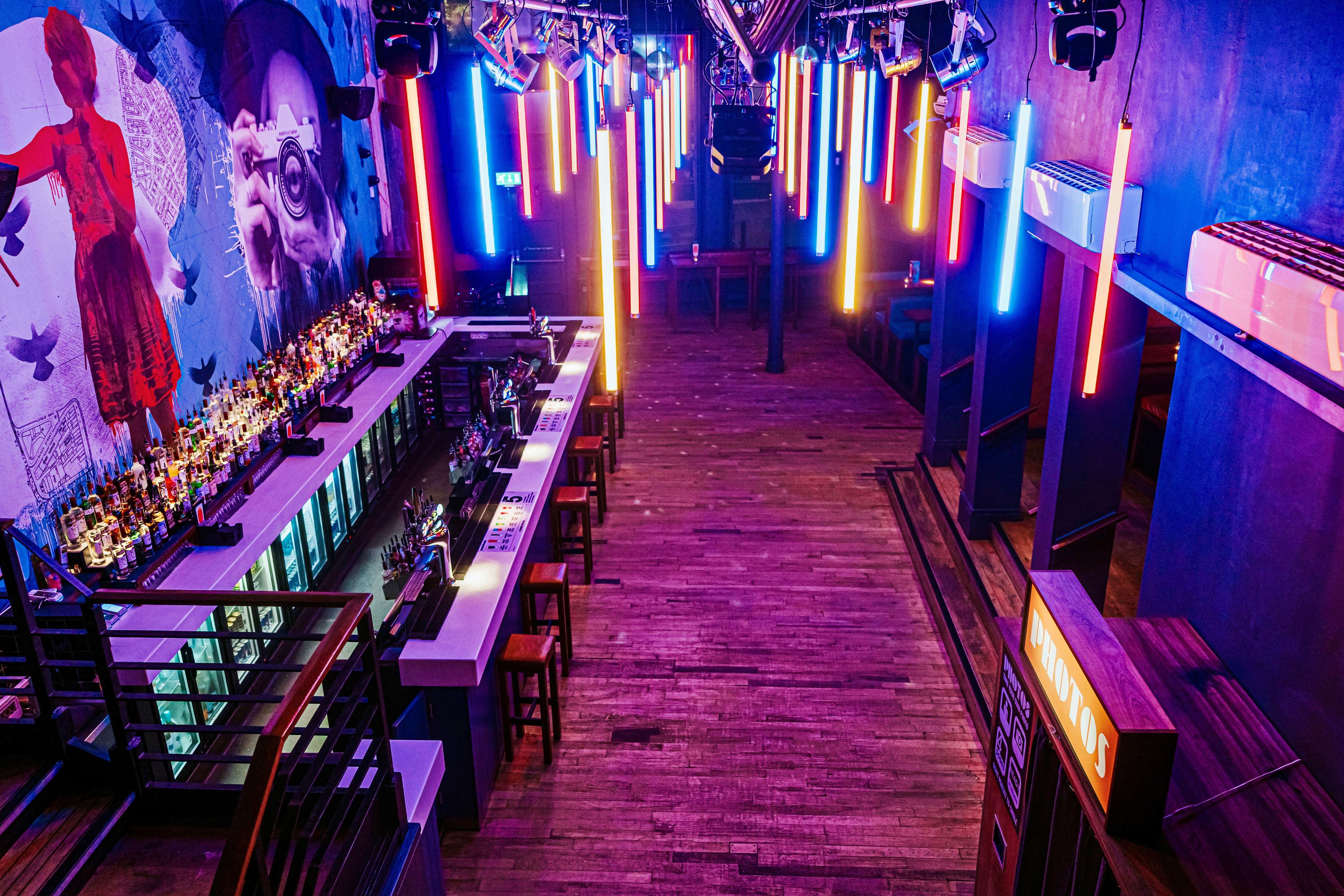 Vibrant Mezzanine Bar in Nottingham with neon lights, perfect for nightlife events.