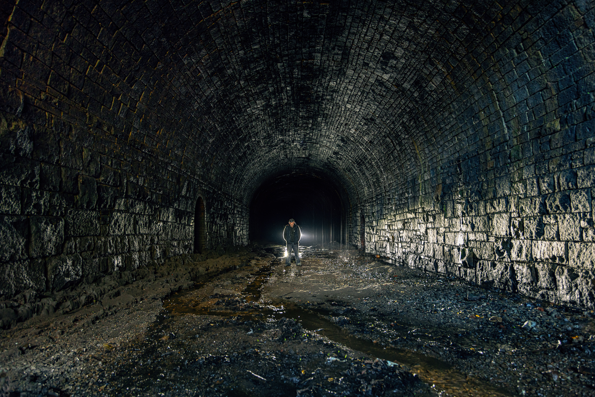 Dimly lit disused railway tunnel for unique event experiences and venue planning.