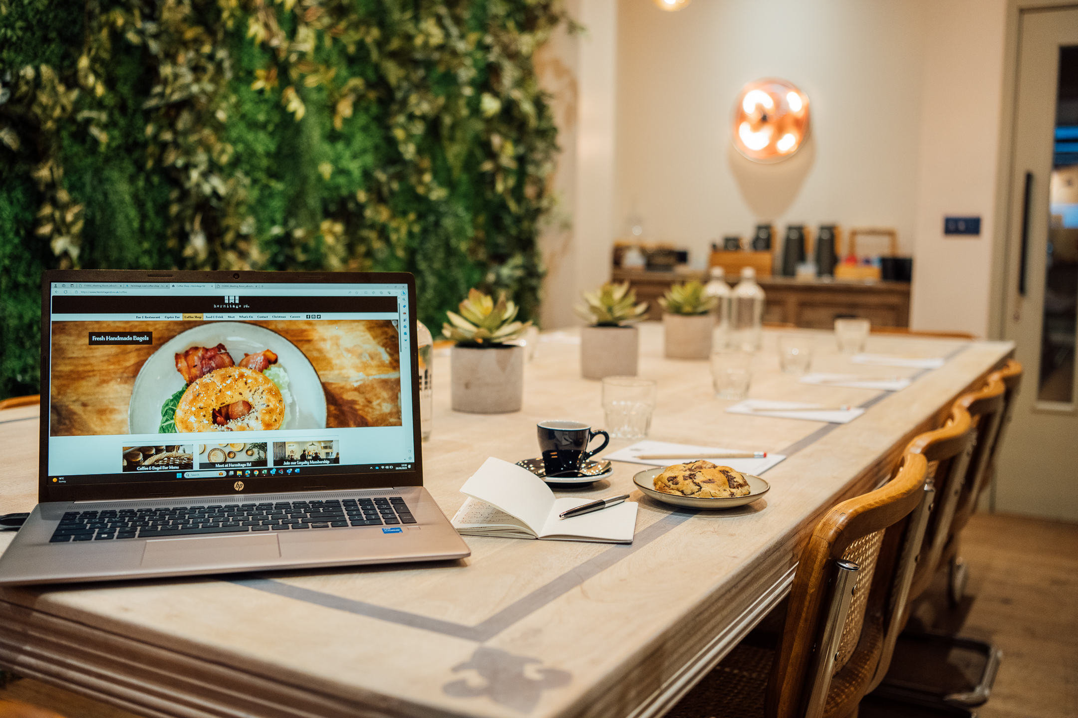 Intimate meeting space at Hermitage Rd Coffee & Bagel Bar with laptop and snacks.