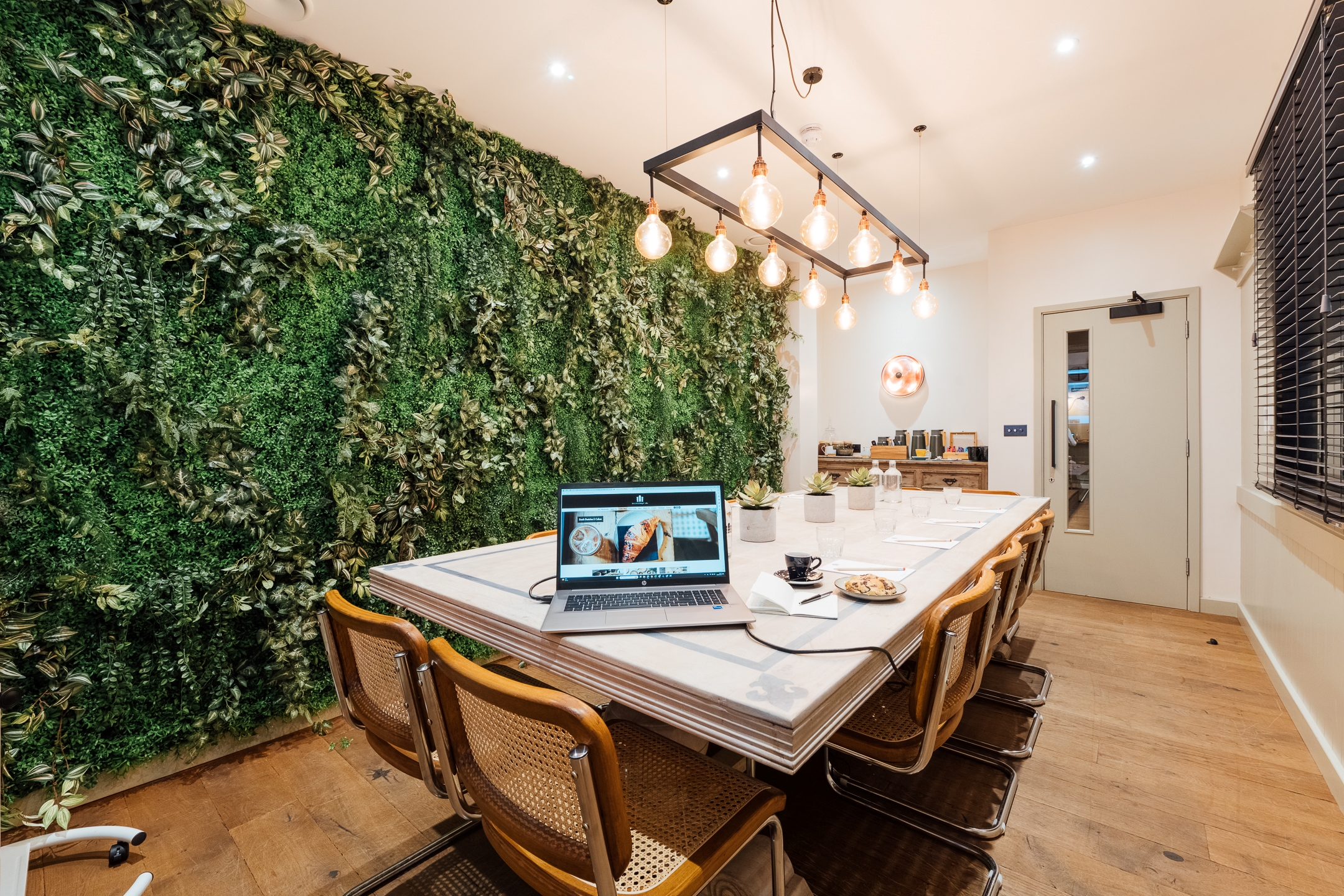 Modern meeting space with lush green wall, ideal for brainstorming and gatherings.