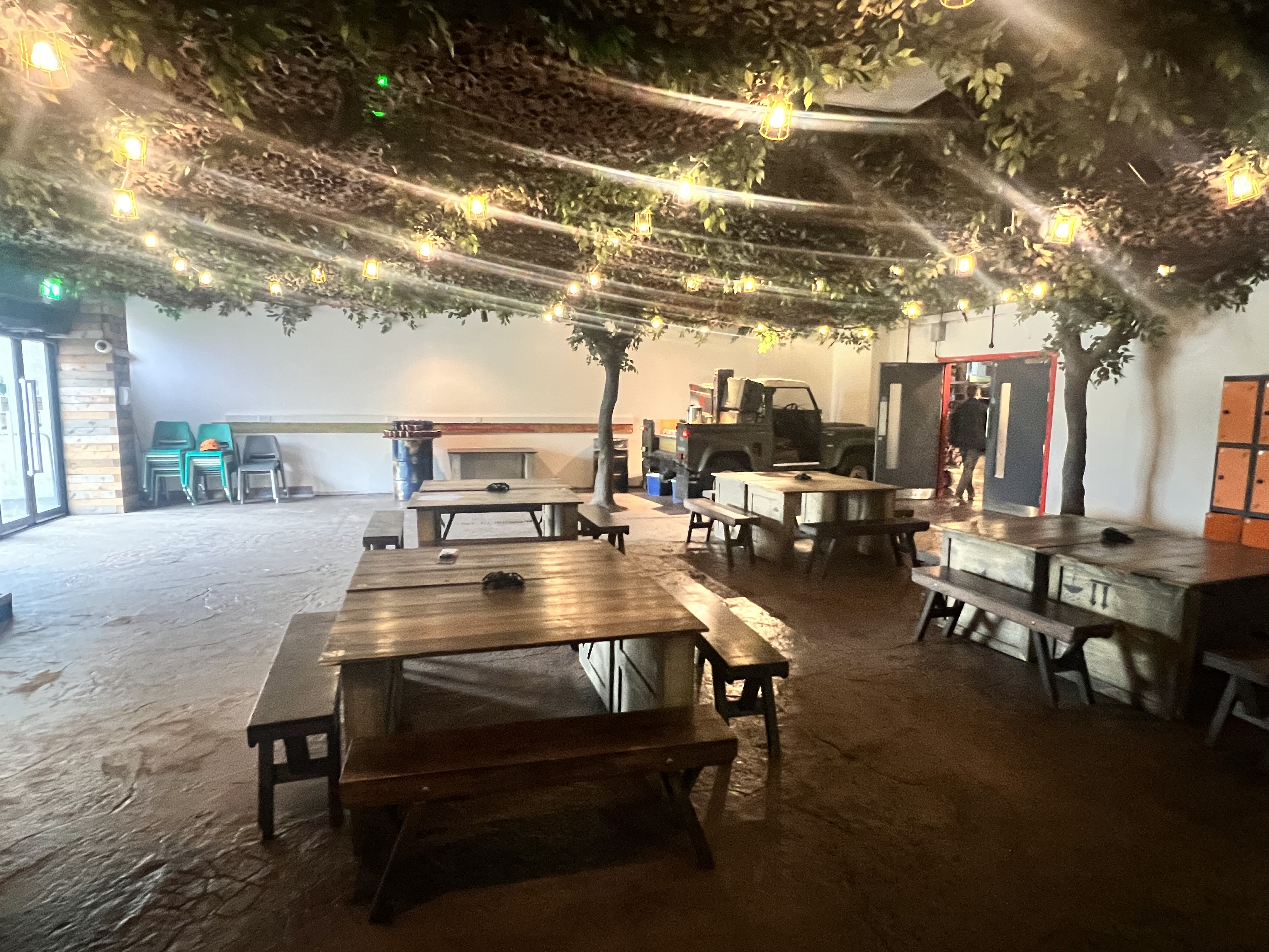 Versatile event space with rustic tables, ideal for gatherings and meetings at Bear Grylls Adventure.