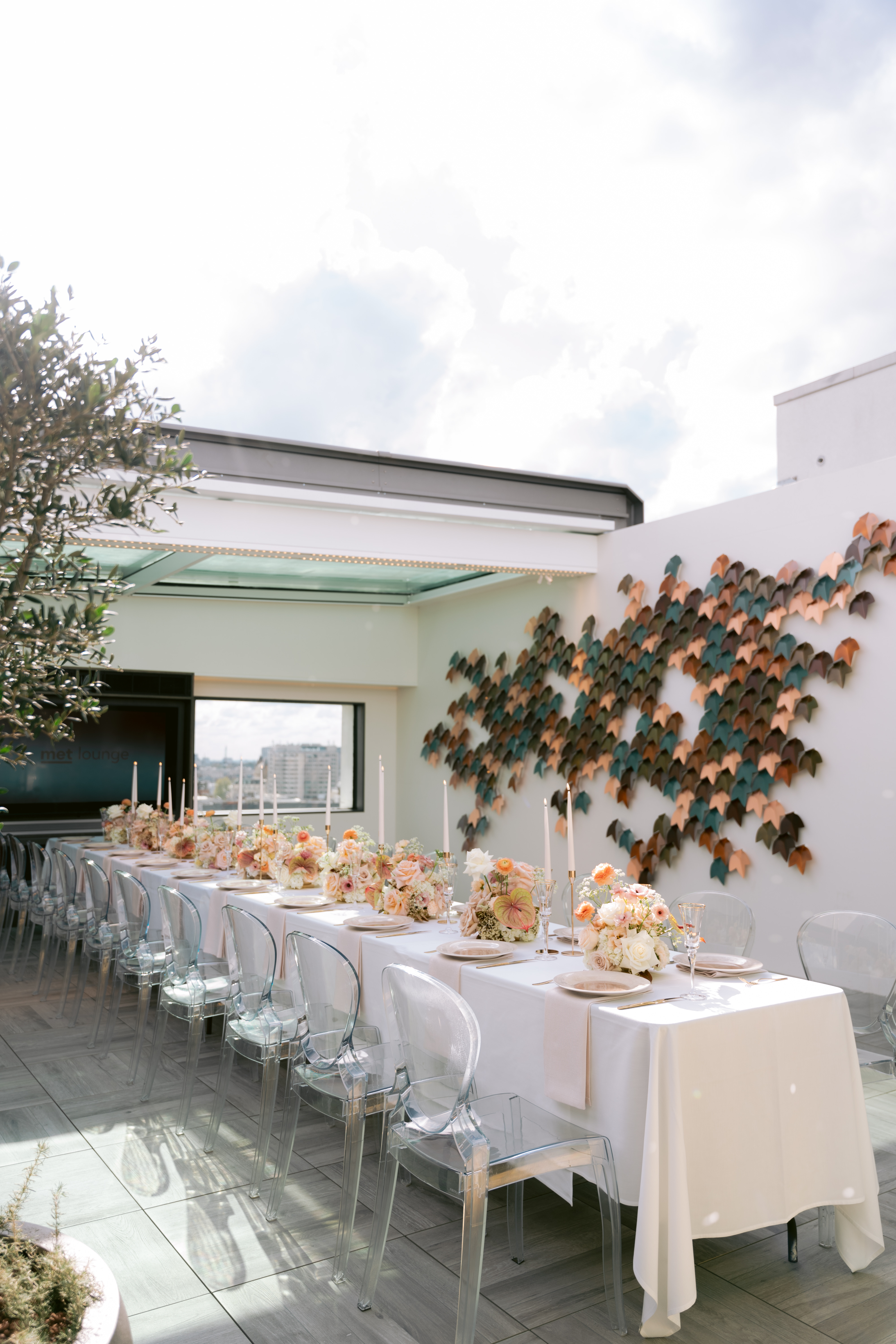 Elegant long table setup in Met Lounge for upscale events with floral decor and candles.