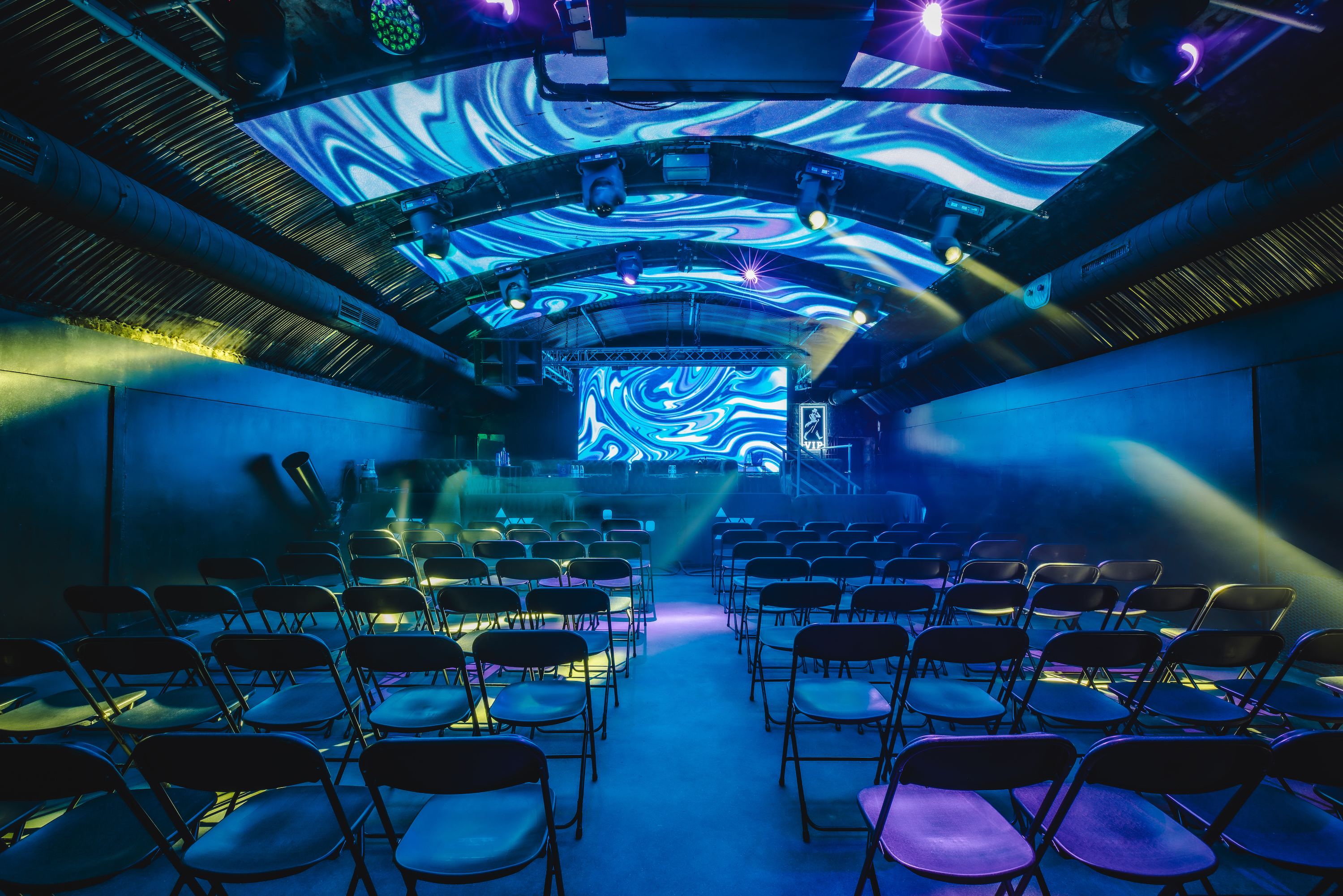 Fire Mirror Arch event space with vibrant lighting for corporate meetings and performances.