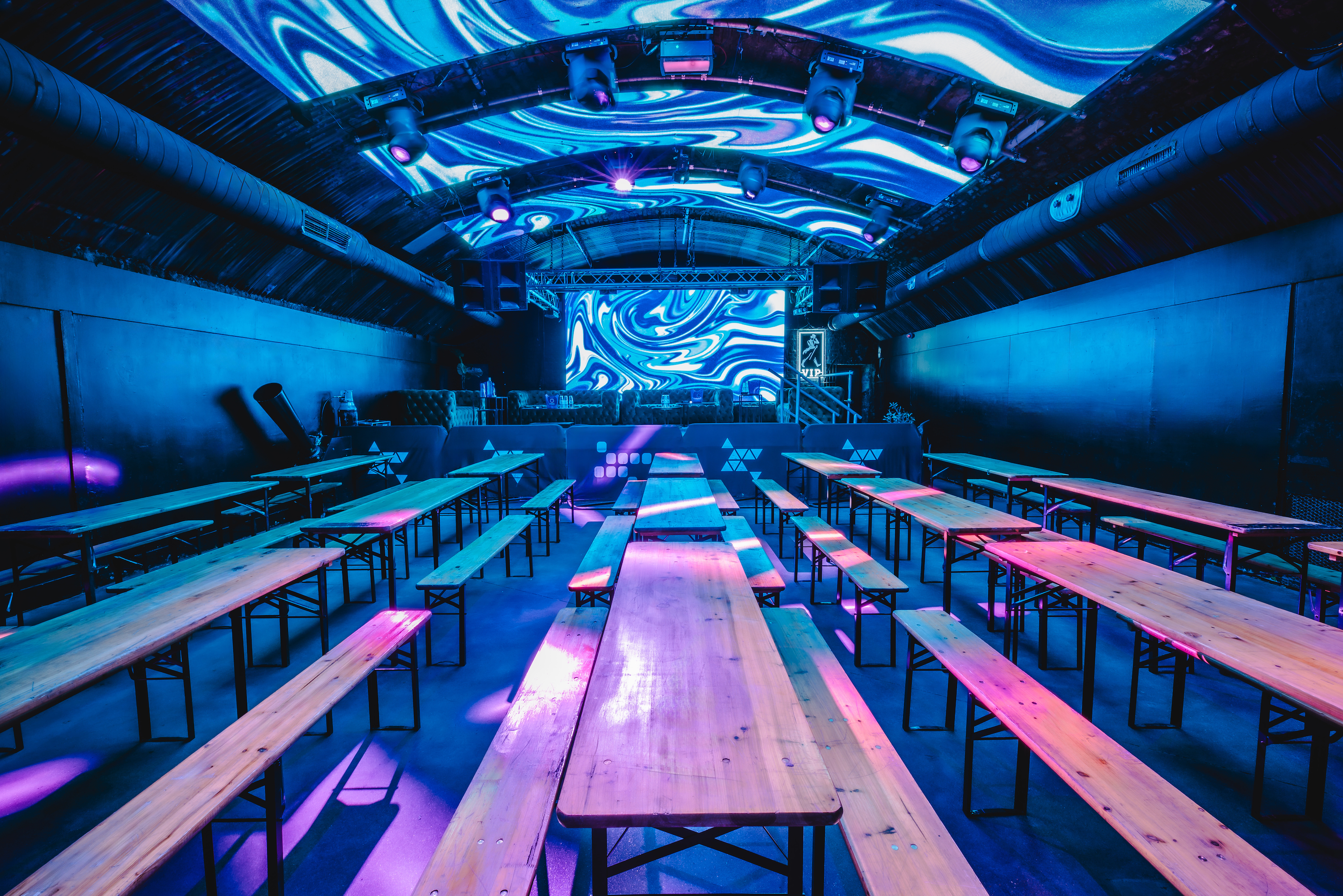 Fire Mirror Arch event space with communal tables, ideal for presentations and gatherings.