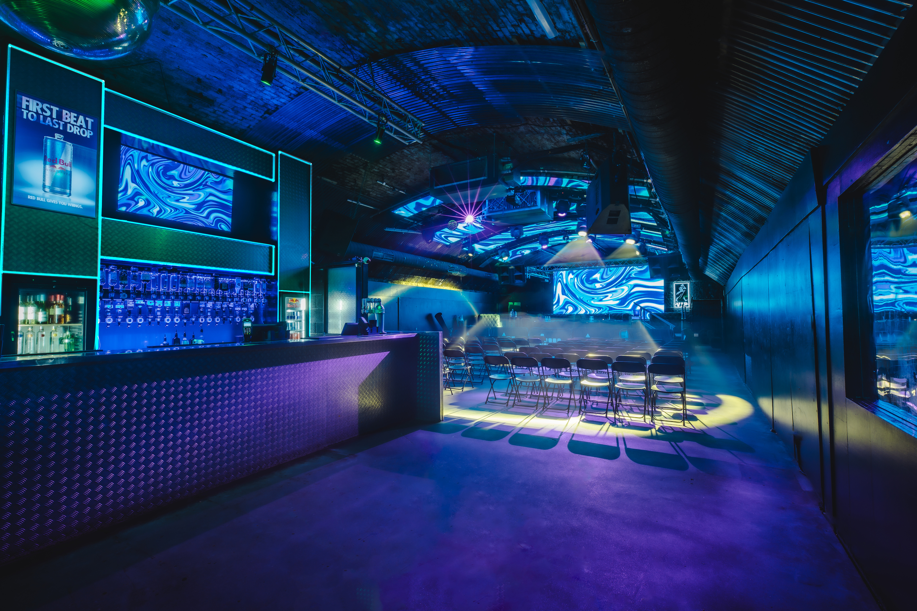 Fire Mirror Arch event space with vibrant lighting, ideal for presentations and networking.