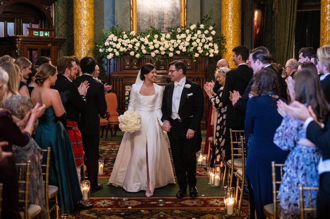 Wedding ceremony in National Liberal Club's Smoking Room, featuring elegant decor and floral arrangements.