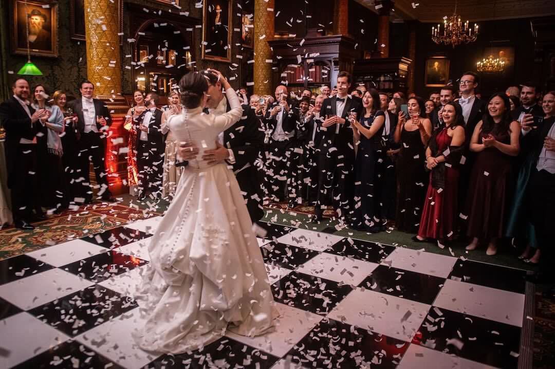 Elegant wedding reception in National Liberal Club's Smoking Room with confetti.
