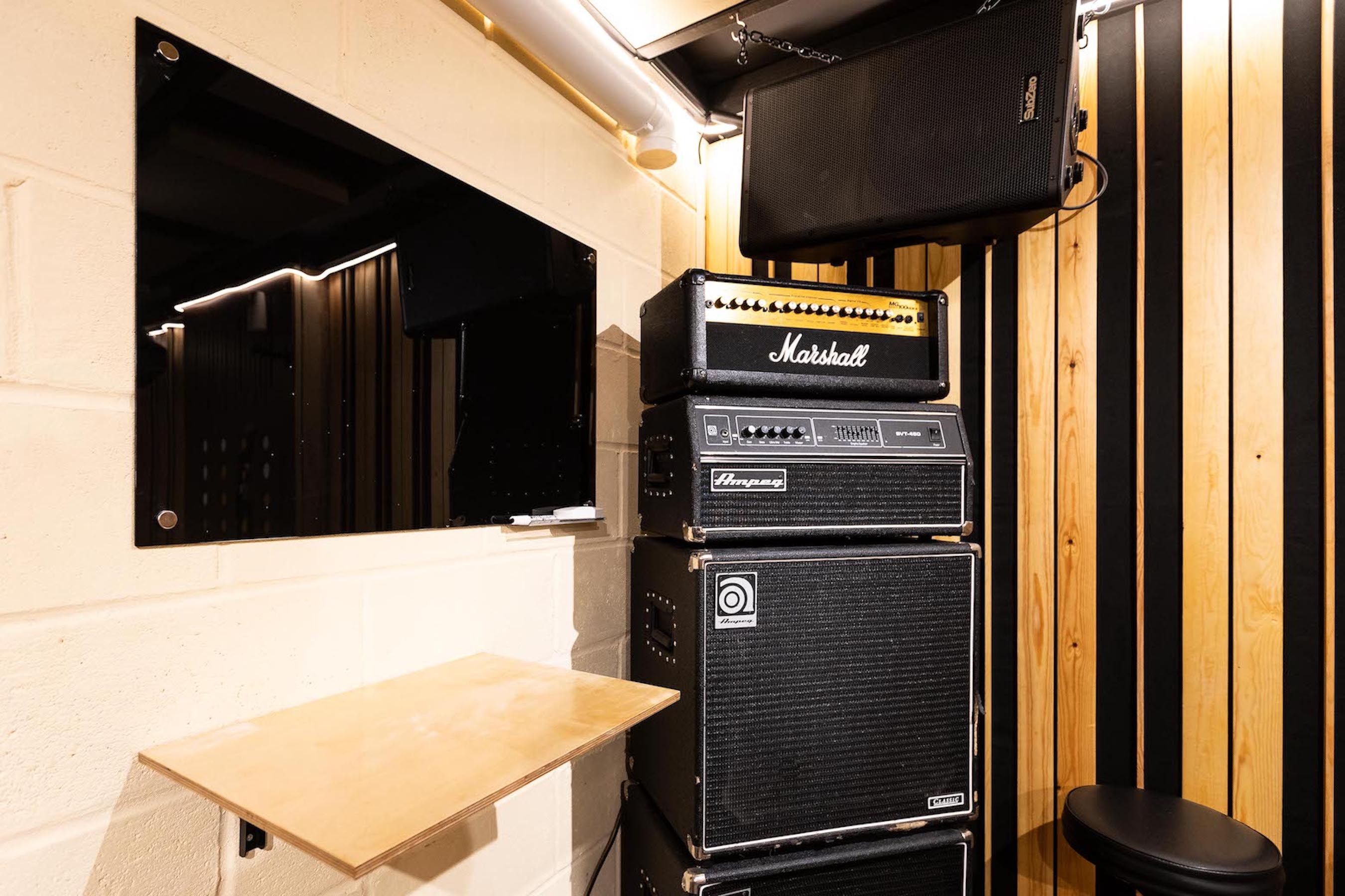 Compact audio setup with amplifiers and monitor for live performances at Yellow Hat Studios.