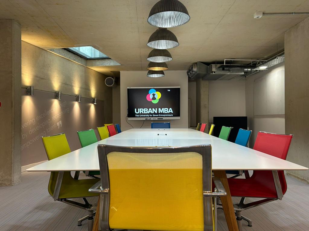 Modern meeting room with colorful chairs, ideal for workshops and brainstorming sessions.