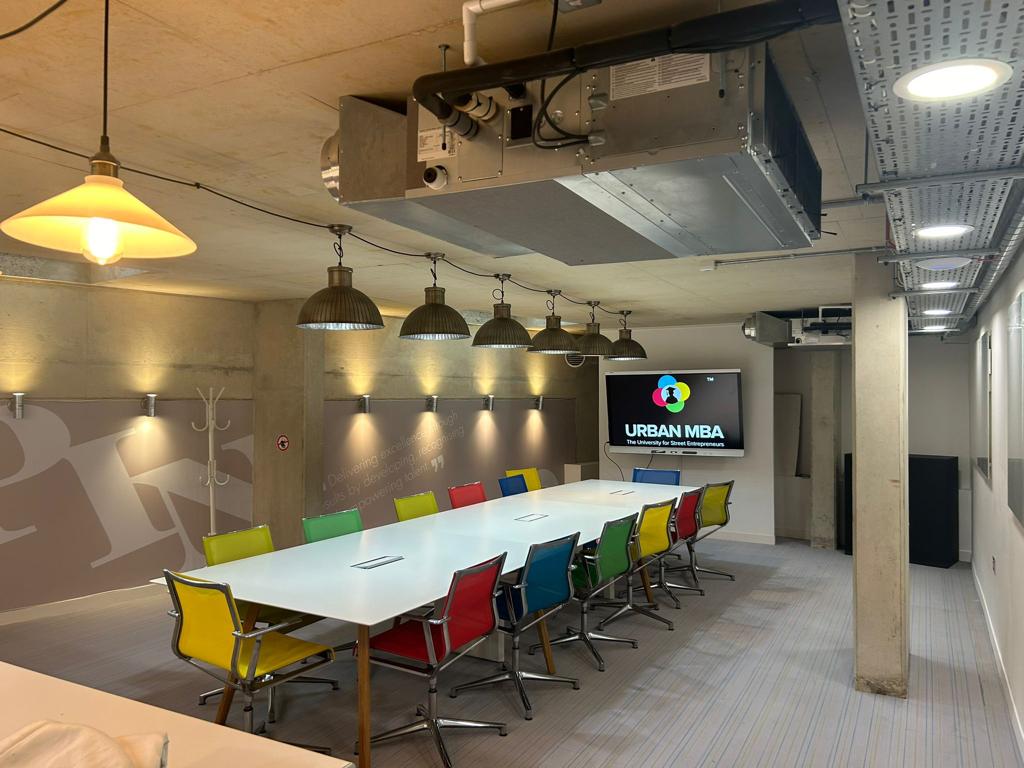 Modern meeting room with colorful chairs, ideal for workshops and brainstorming sessions.