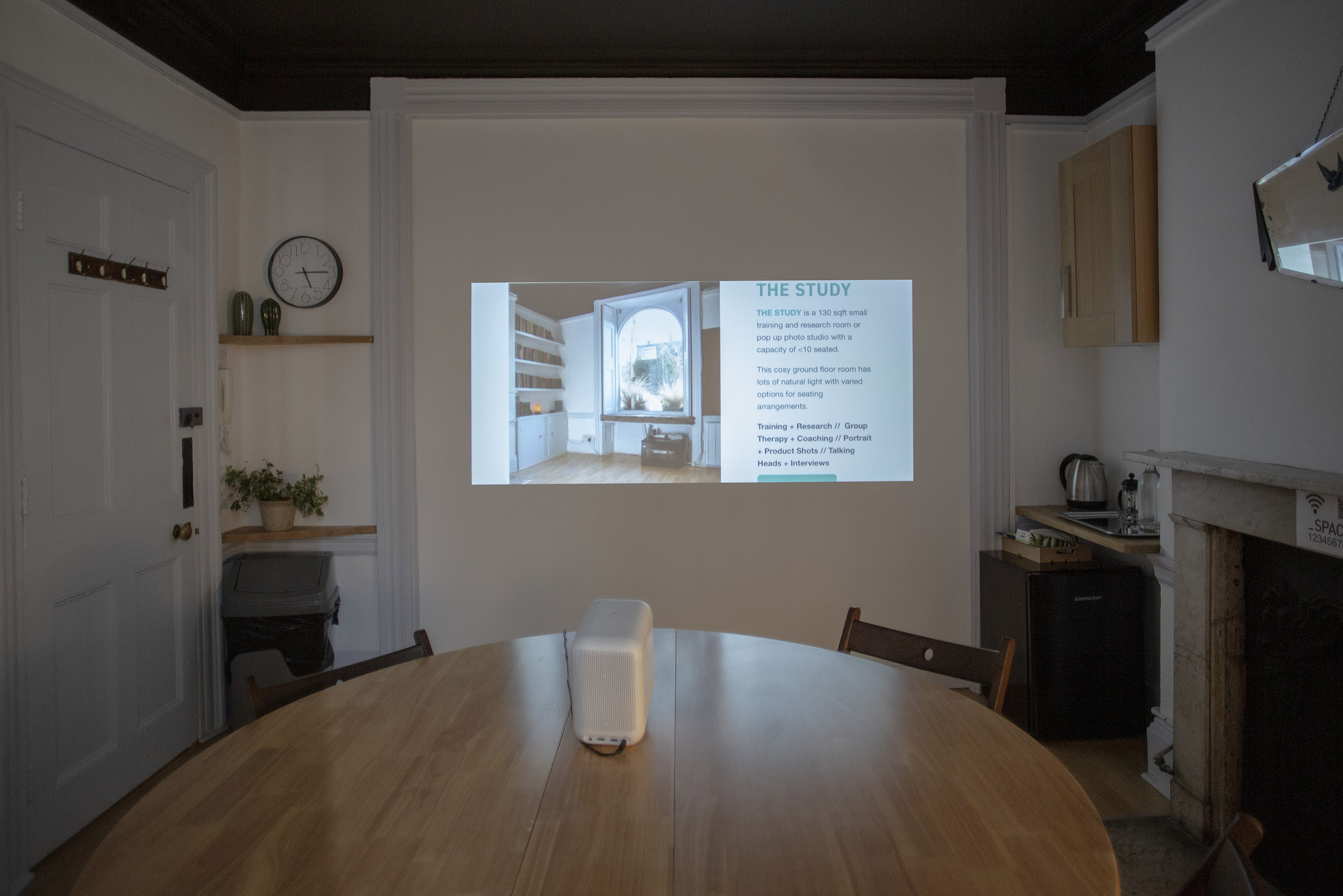 "Intimate meeting space with round table, ideal for workshops and team presentations."