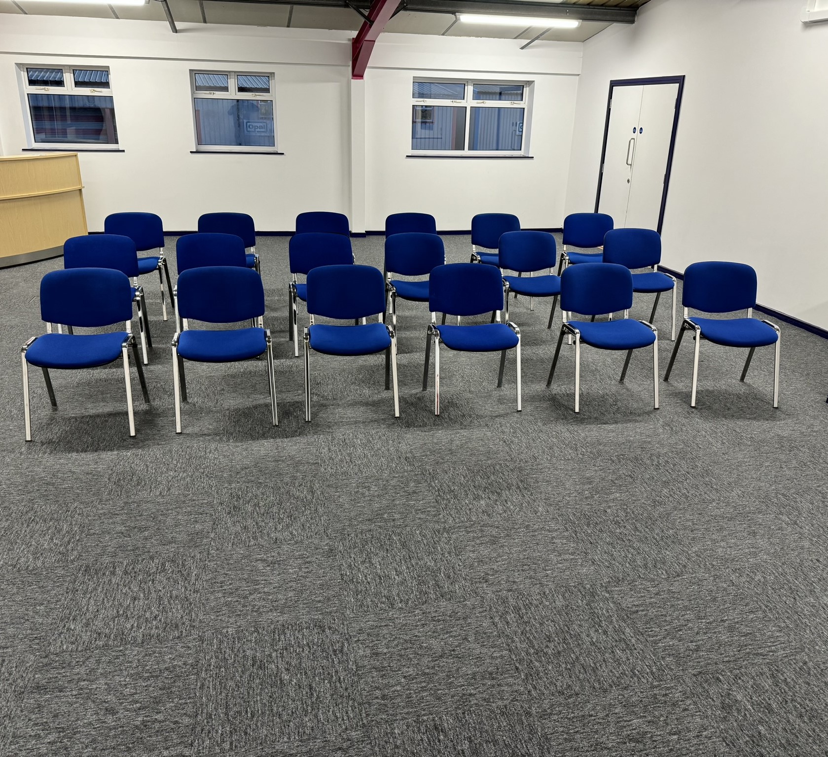 Blue chairs in a semi-circle at a UK training centre for workshops and meetings.