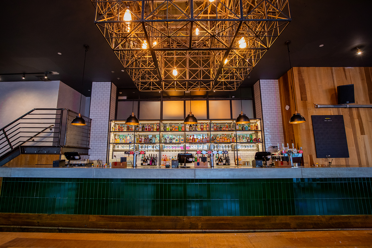 Stylish bar with geometric light fixture, ideal for networking events and cocktail receptions.