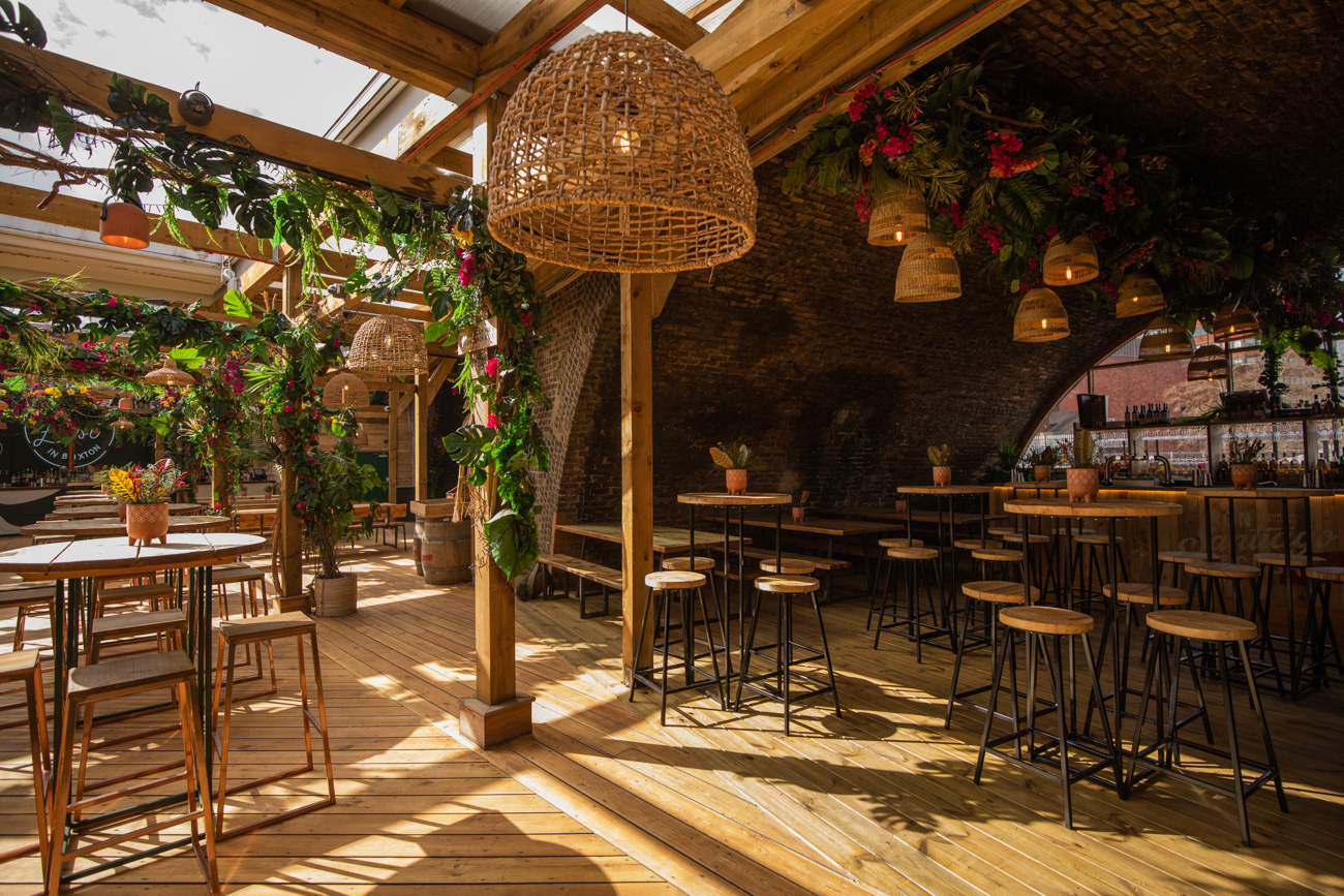 The Arches in Pergola Brixton: stylish event space with natural wood and greenery.