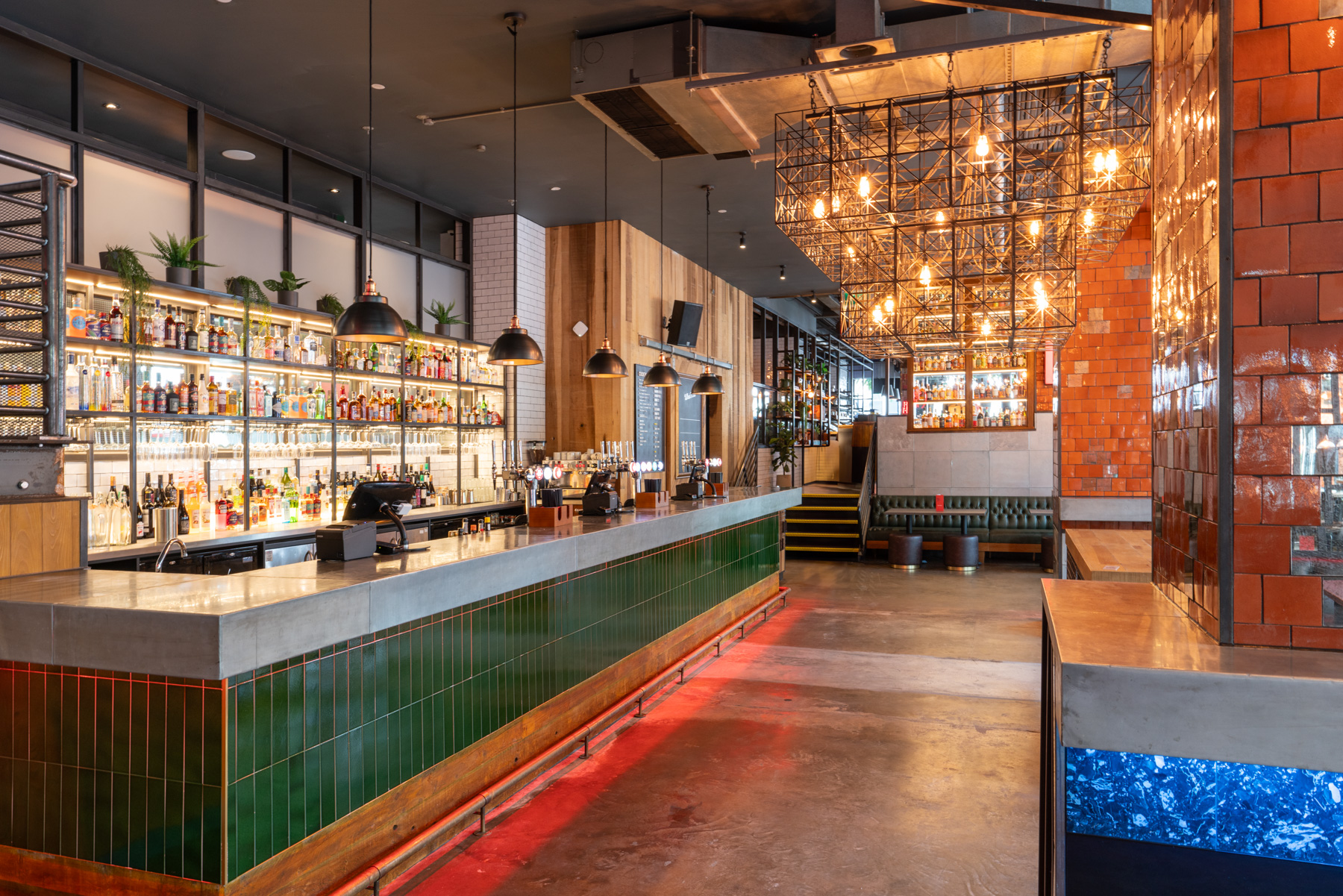 Stylish bar area with vibrant lighting, ideal for networking events and social gatherings.