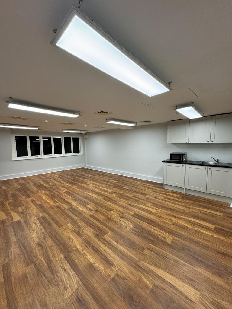 Versatile meeting space in Widegate E1 with natural light, ideal for workshops and gatherings.