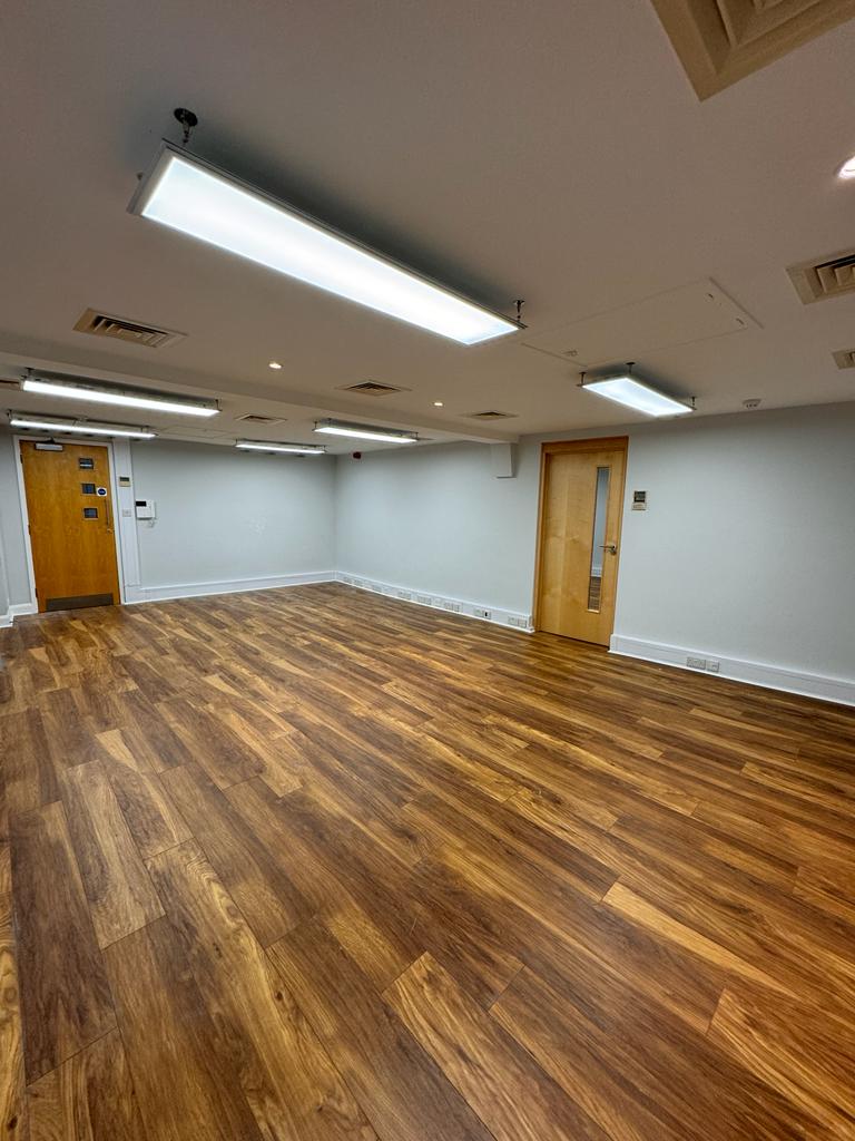 Versatile meeting space in Widegate E1 with wooden flooring for events and workshops.
