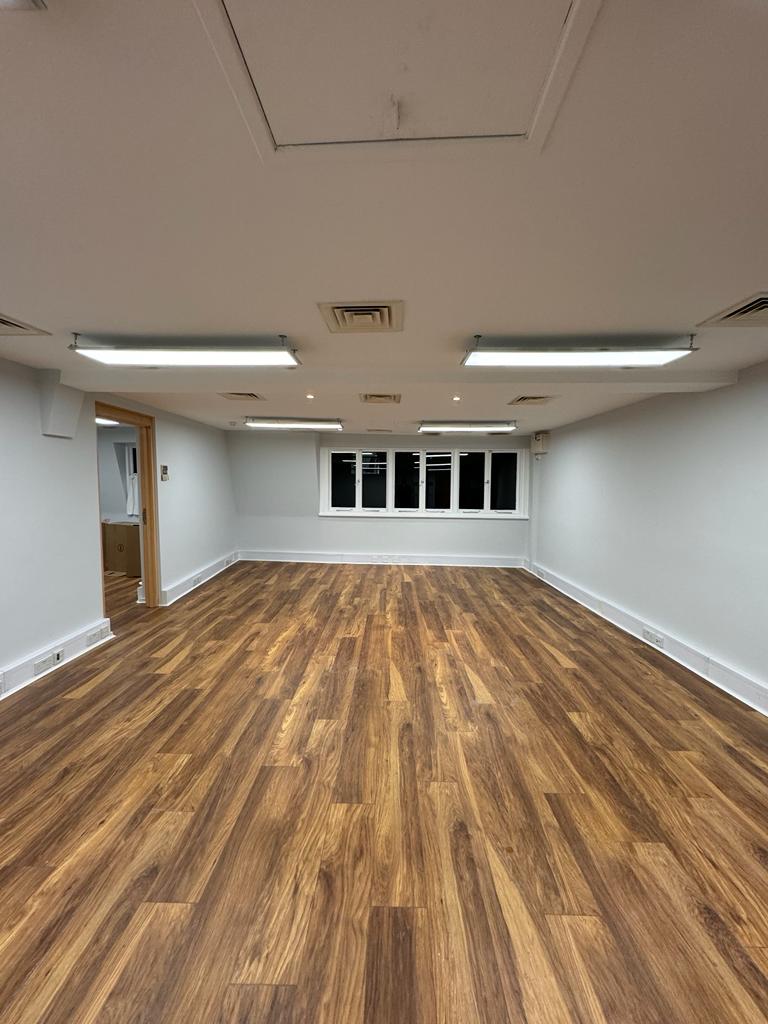 Versatile meeting space in Widegate E1 with hardwood flooring for events and workshops.