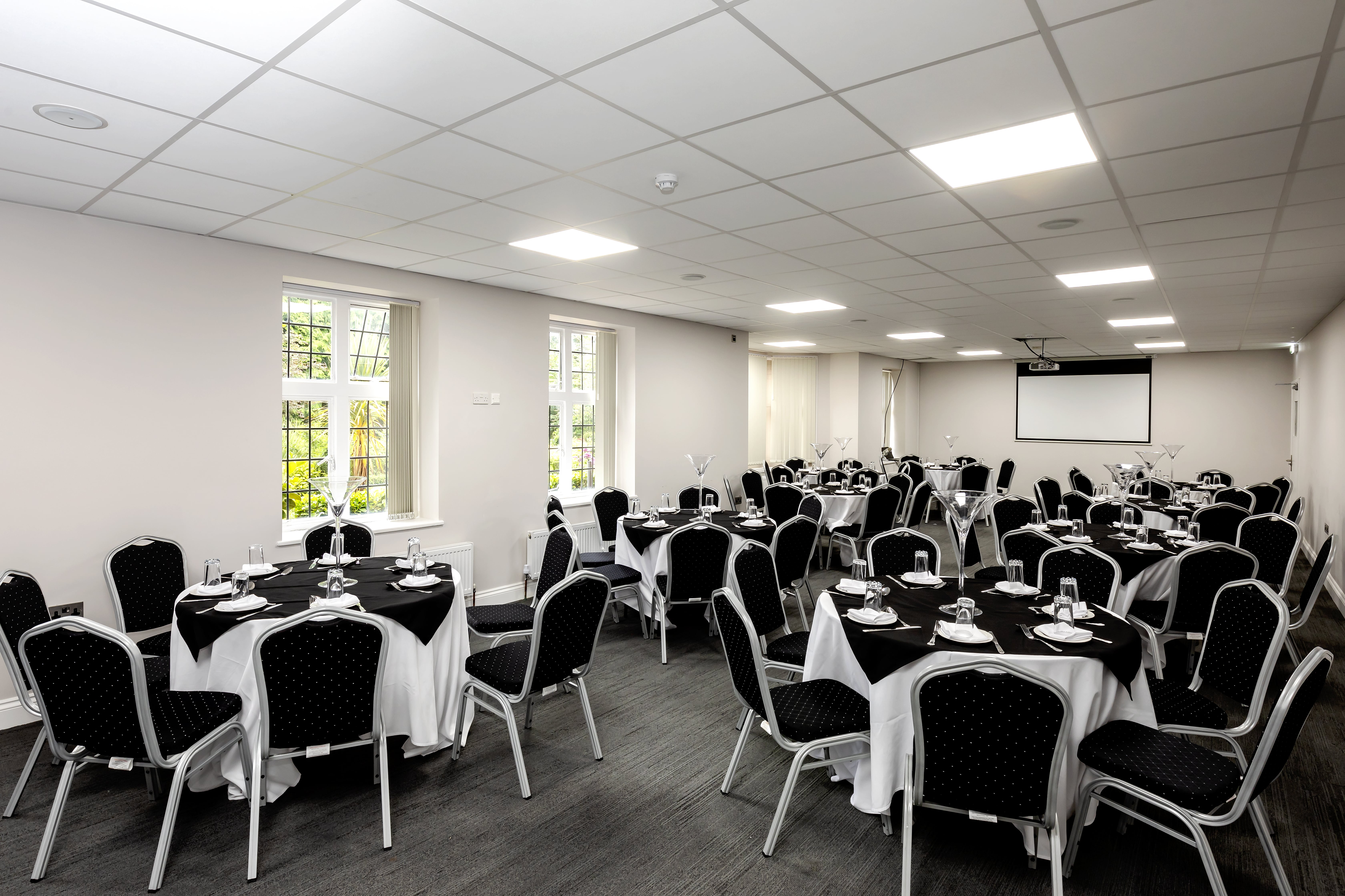 Bright conference room with round tables, perfect for formal dinners and networking events.