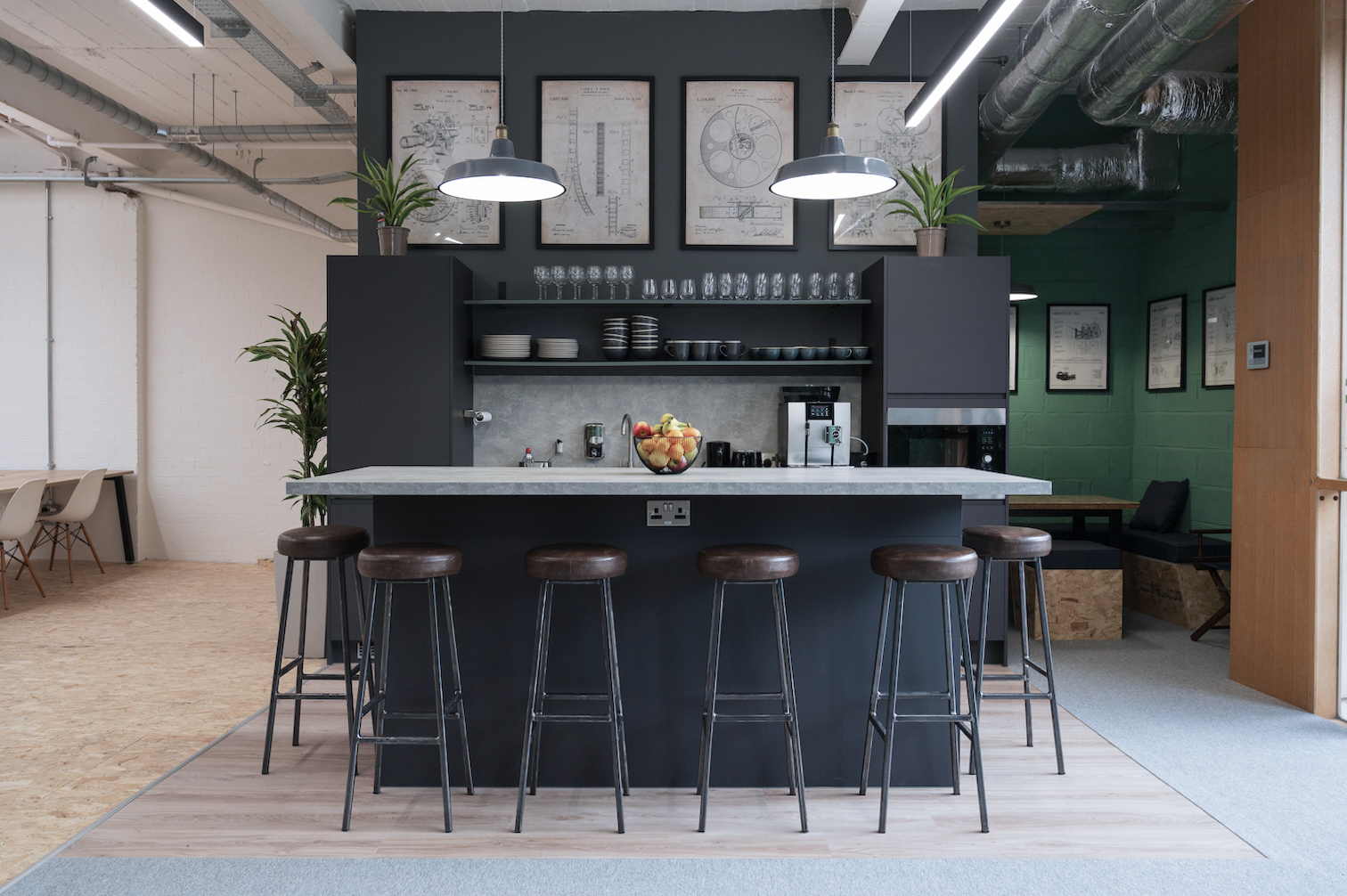 Modern networking space in FOMO House with sleek bar counter and greenery.