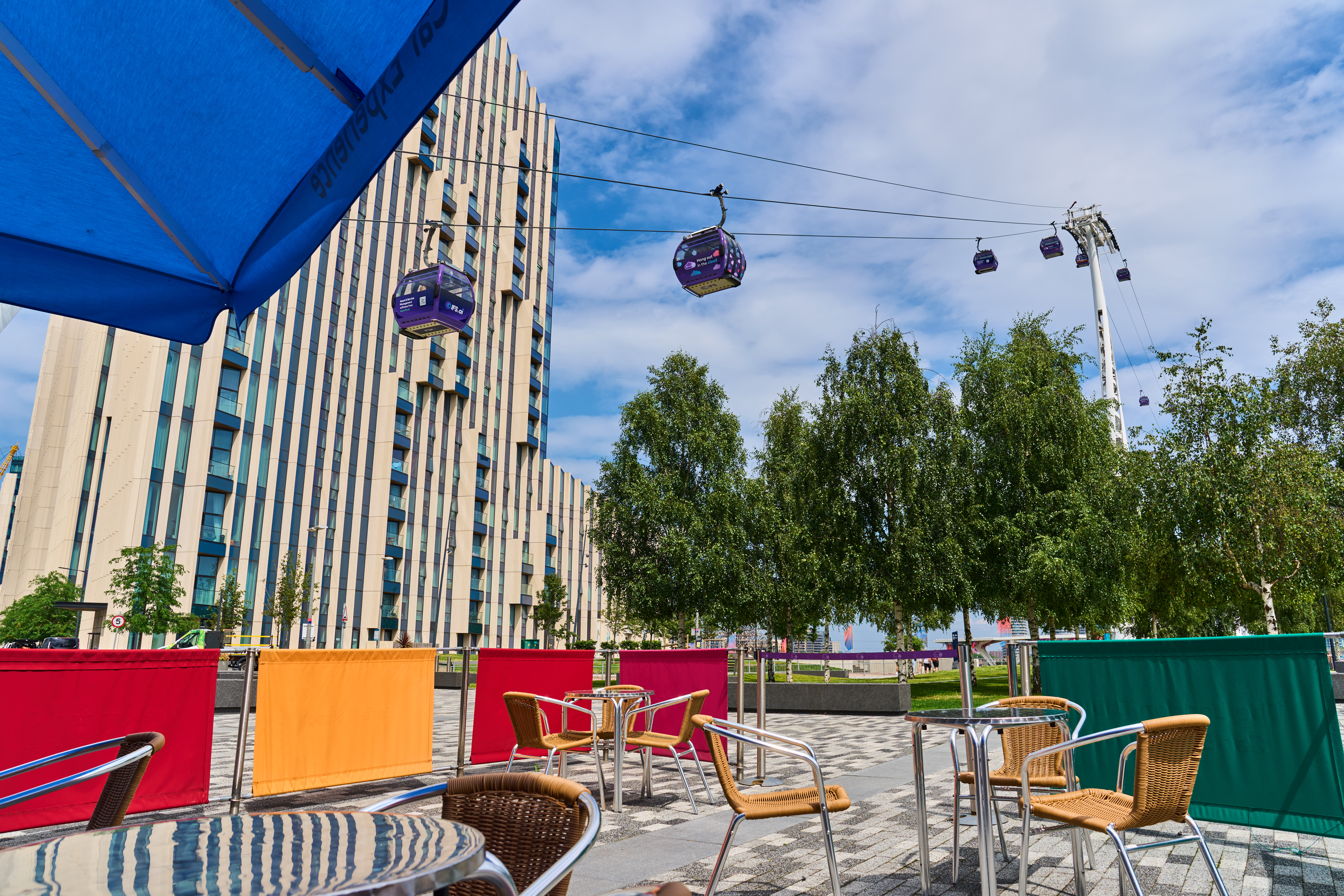 Outdoor networking space at London Cable Car with colorful barriers for events.