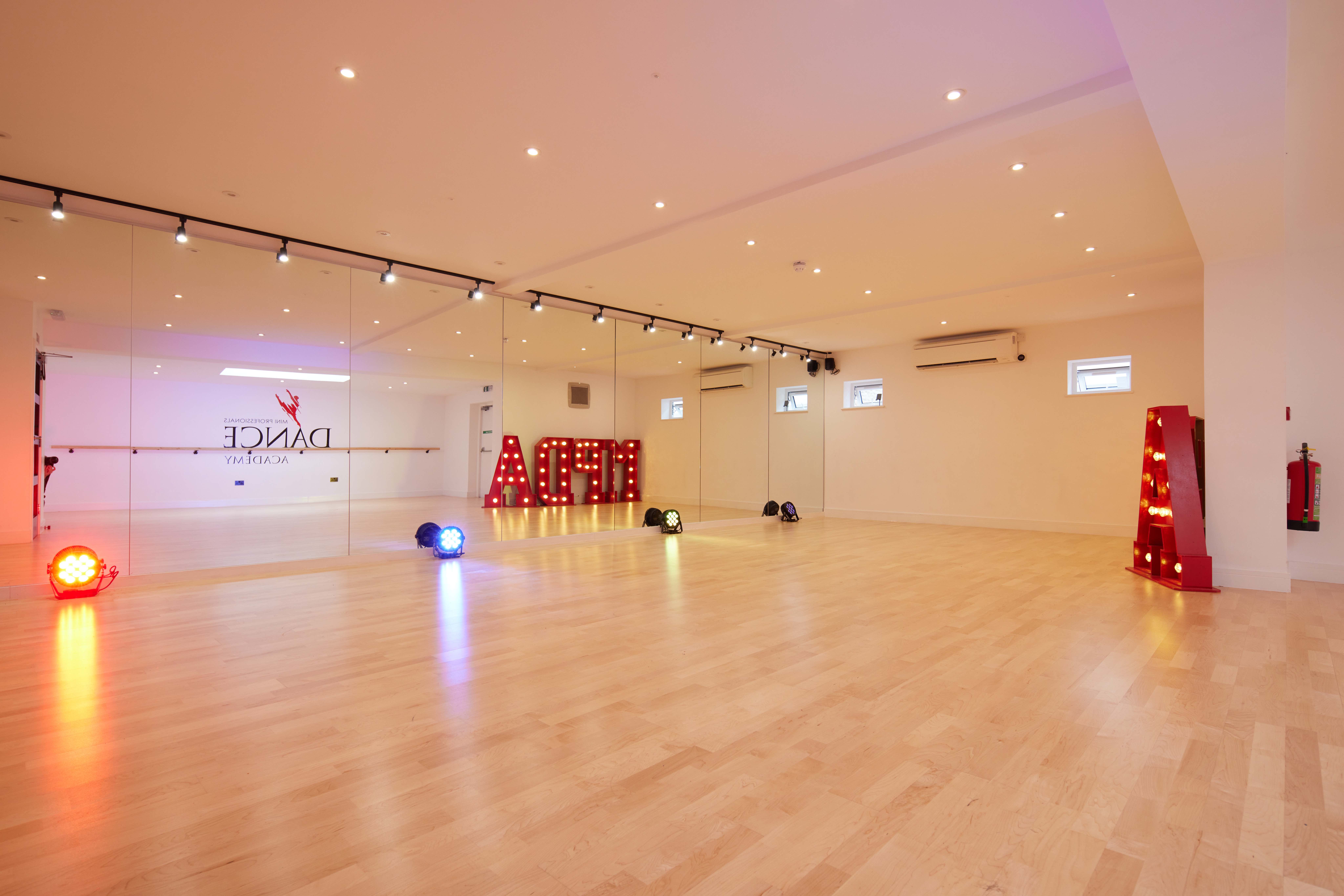 Versatile dance studio with polished wooden floors, ideal for workshops and events.