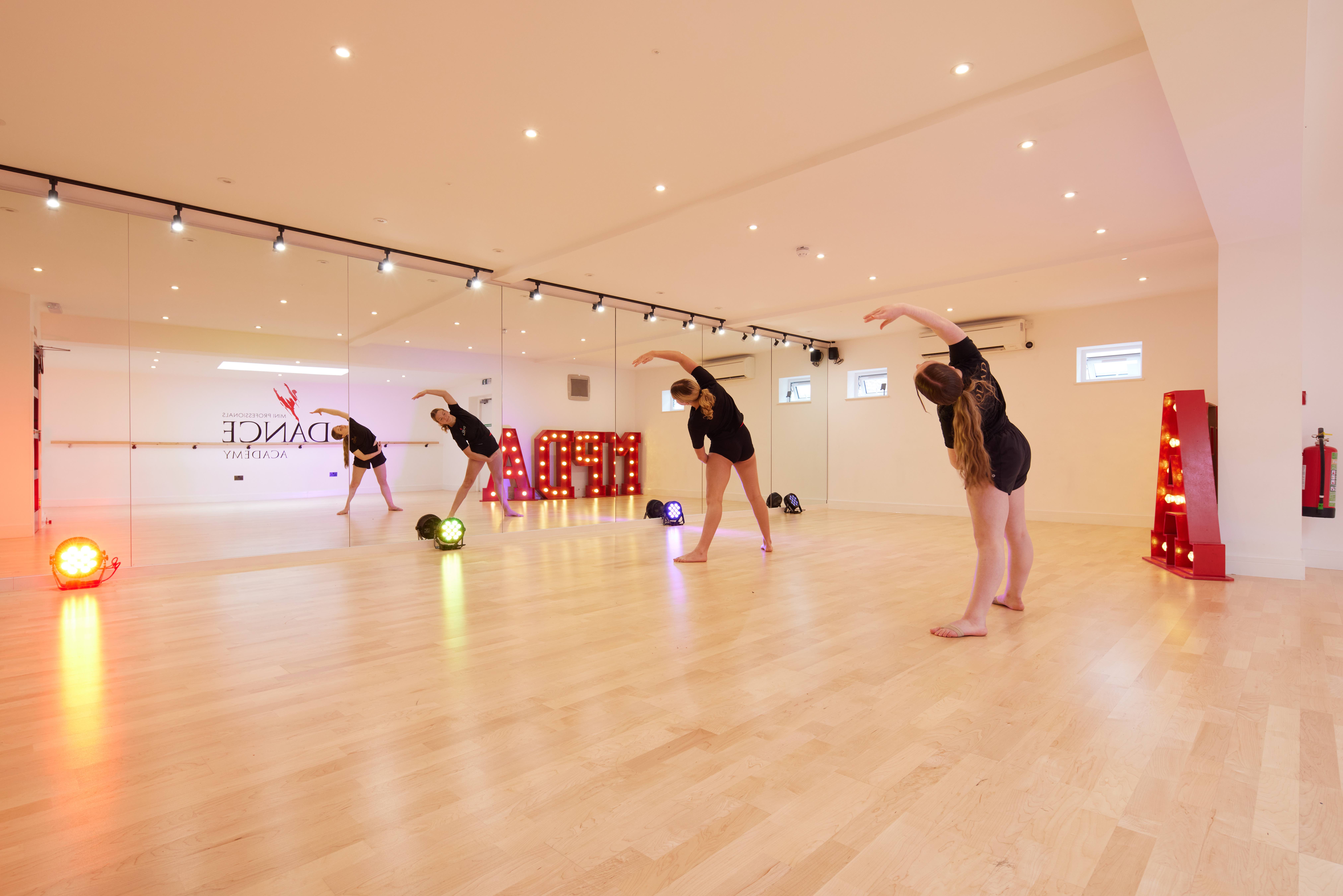 Spacious dance studio with mirrored walls, ideal for workshops and fitness events.
