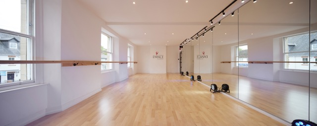 Bright dance studio with mirrors and wooden floor, ideal for workshops and classes.
