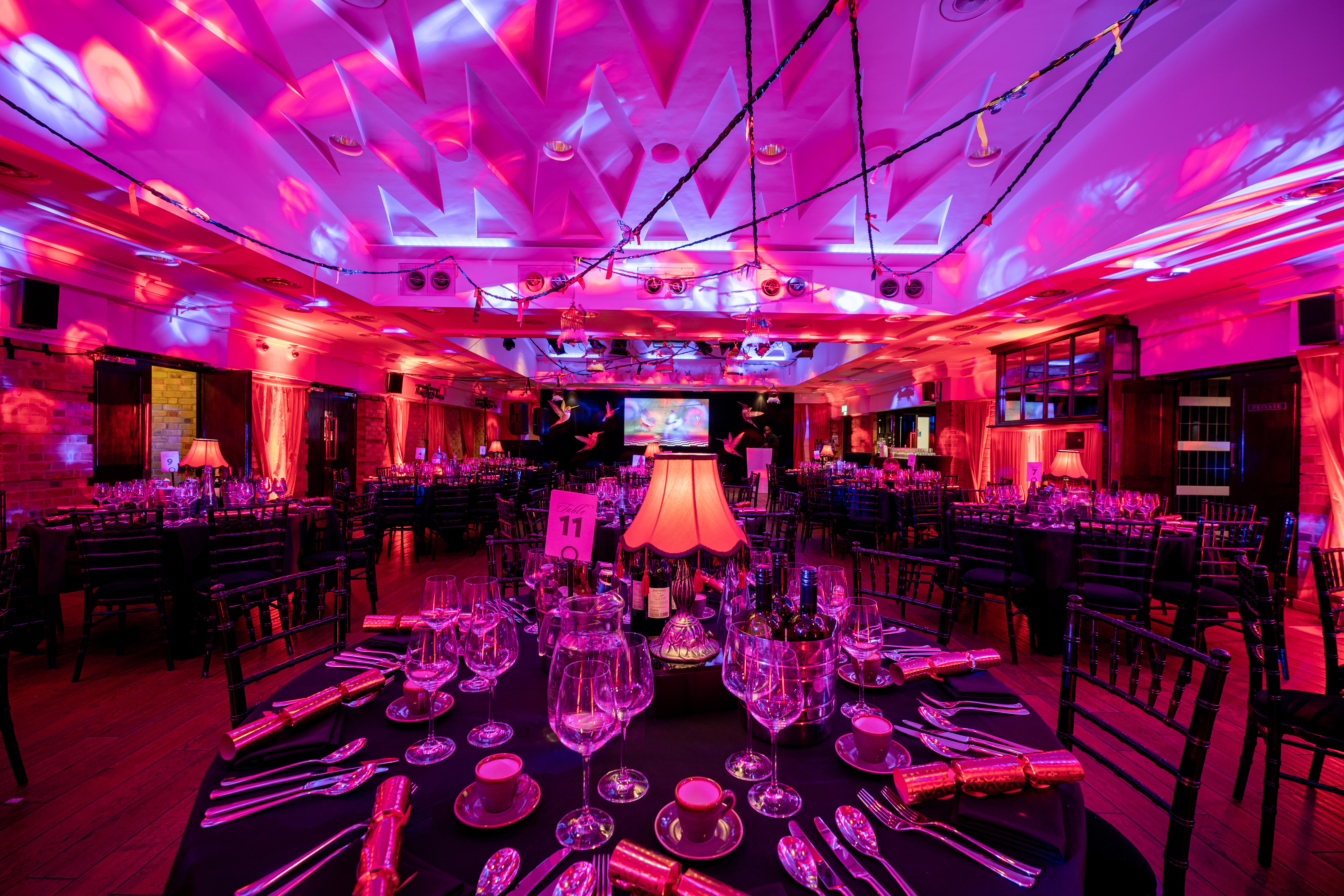 Elegant Christmas party setup with fine glassware in a festive event space.