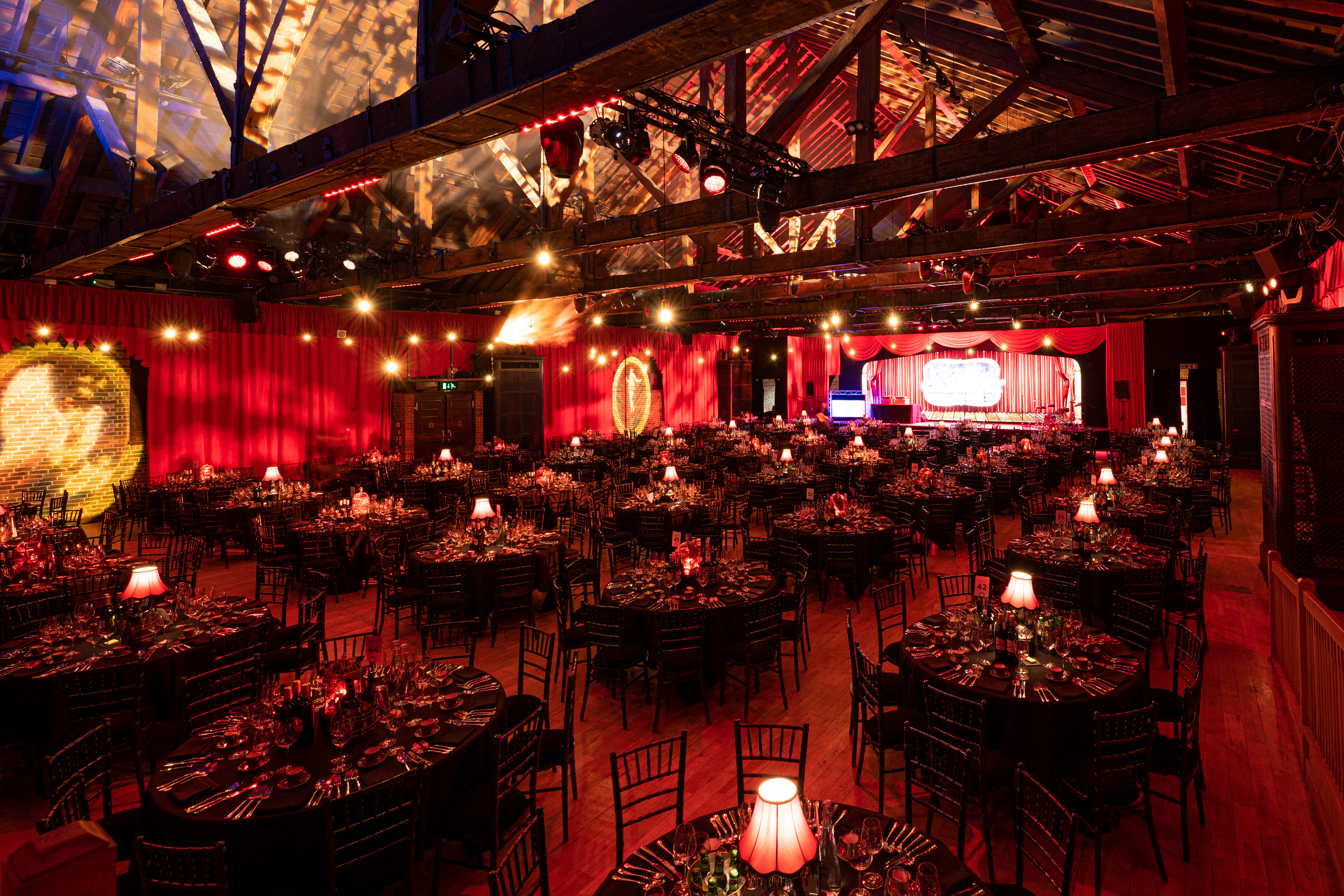 Elegant Christmas party setup with round tables and ambient lighting at The Brewery.