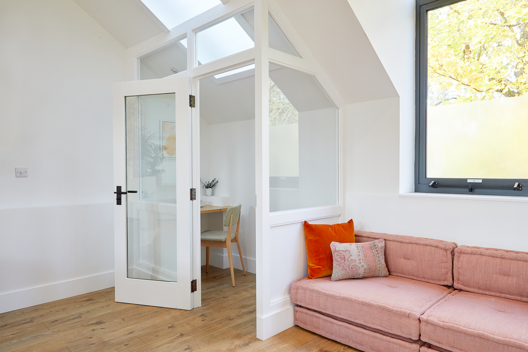 Modern meeting space with pink sofa, ideal for intimate brainstorming sessions.