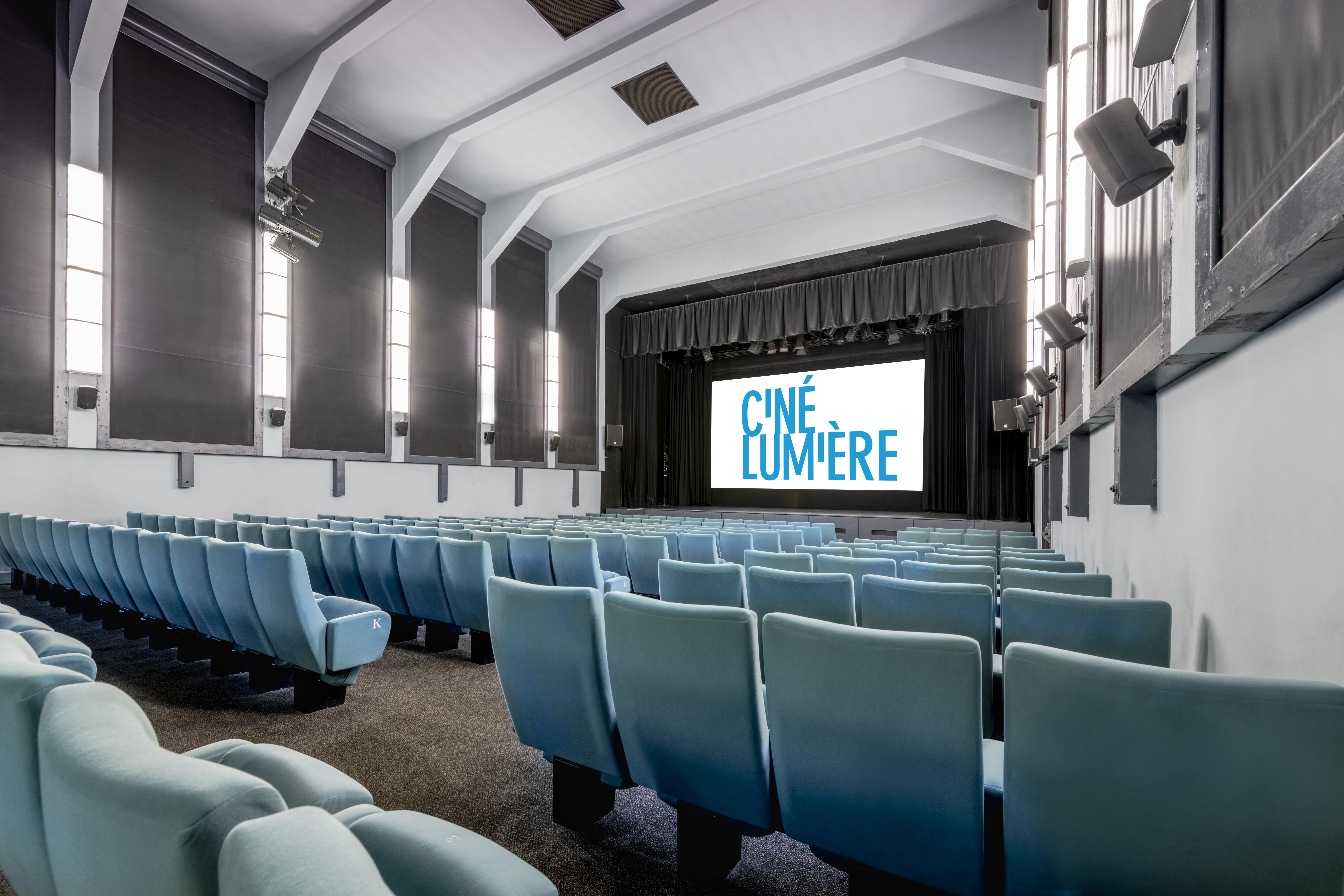 Ciné Lumière auditorium with blue chairs, ideal for film screenings and events.