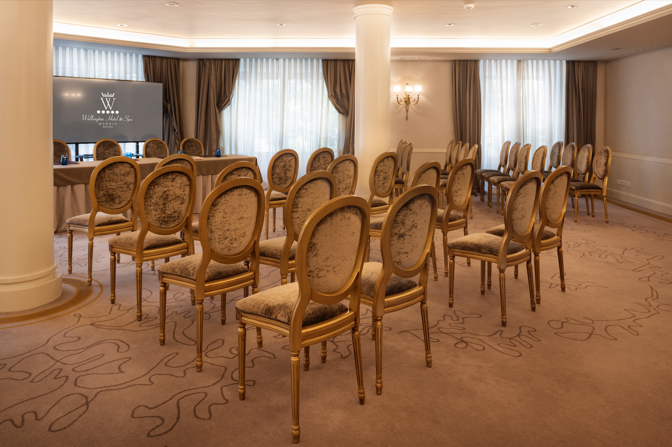 Elegant meeting room with gold-accented chairs for corporate events in Madrid.