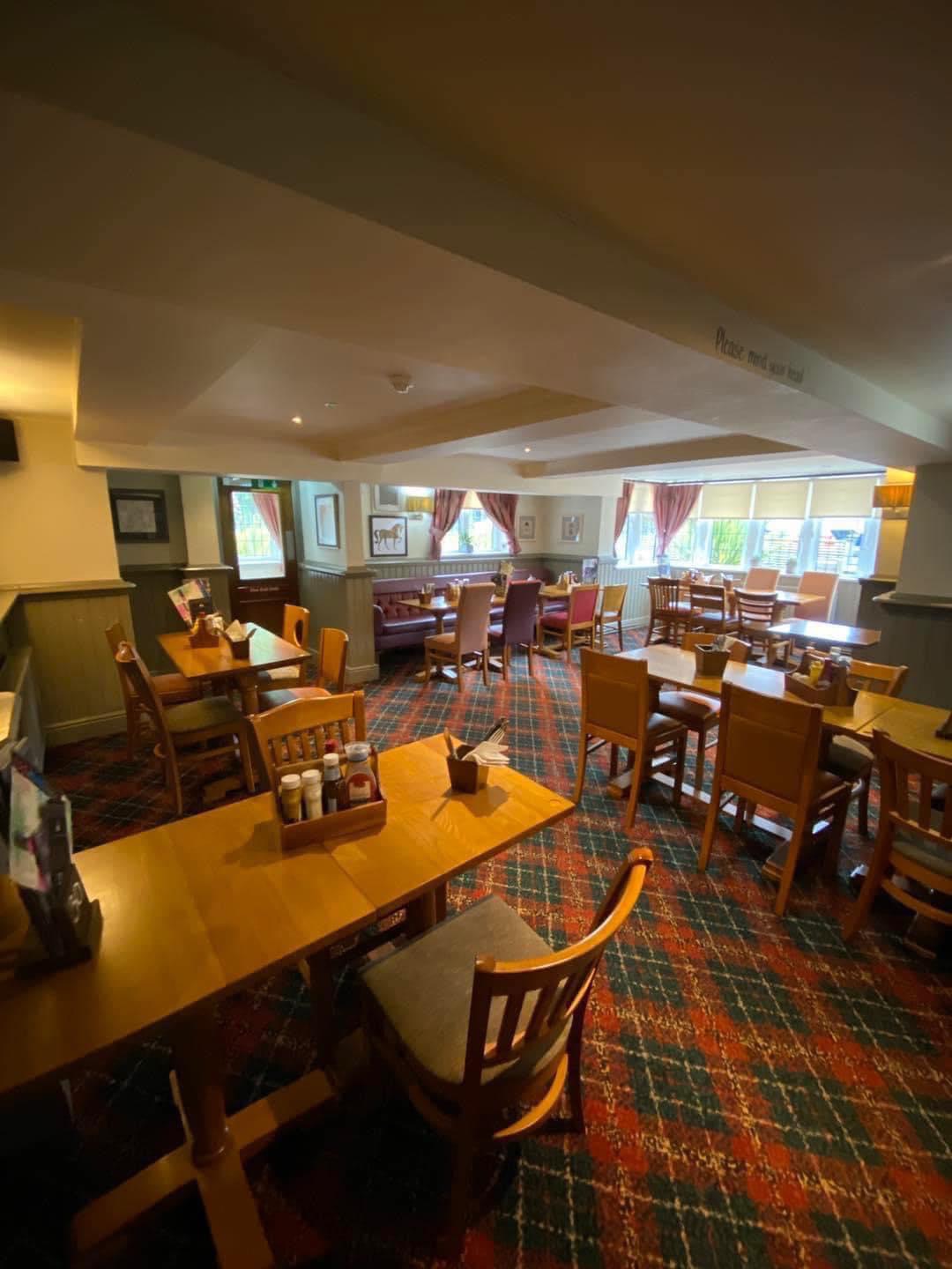Cozy meeting space at The Bowling Green with wooden tables for events and gatherings.