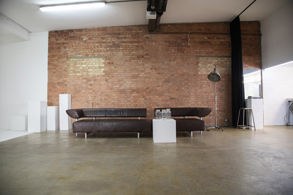 Modern event space in Bow Bunker, East London with exposed brick and leather sofa.