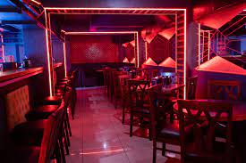 Vibrant cocktail bar lounge with neon lighting, perfect for parties and networking events.