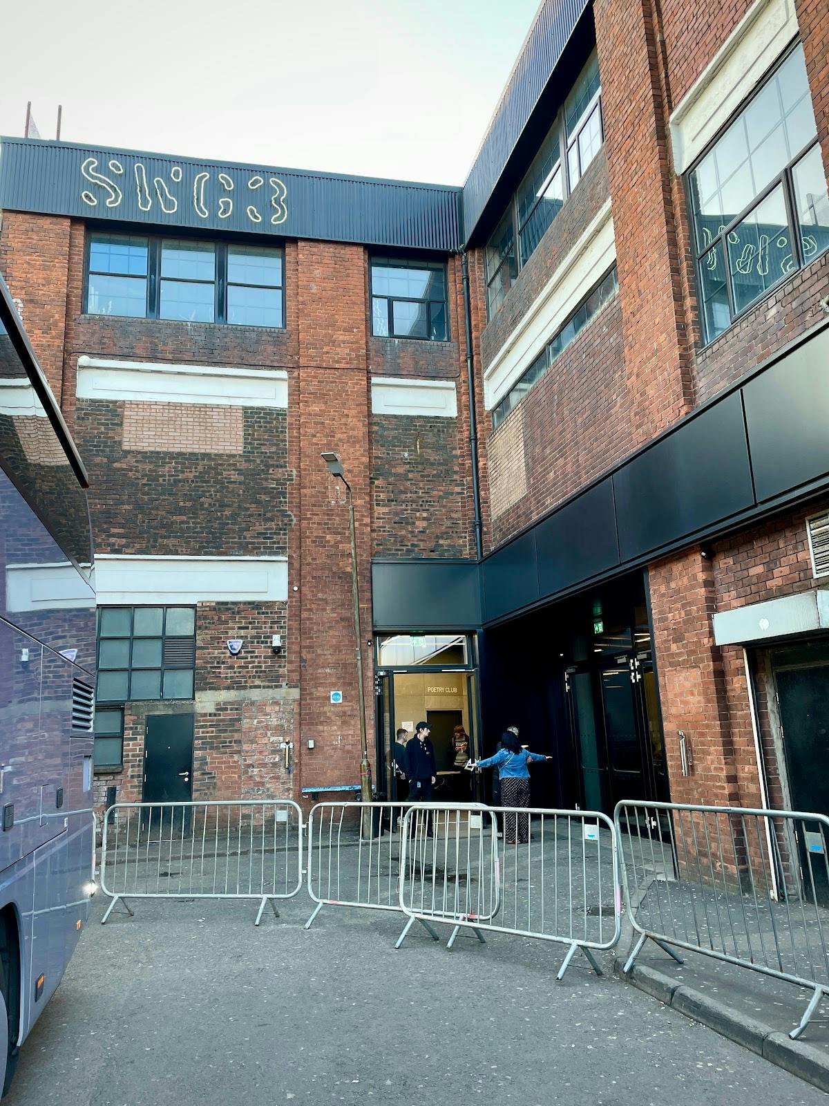 Acid Bar entrance at SWG3, modern facade with brick backdrop, event venue setup.