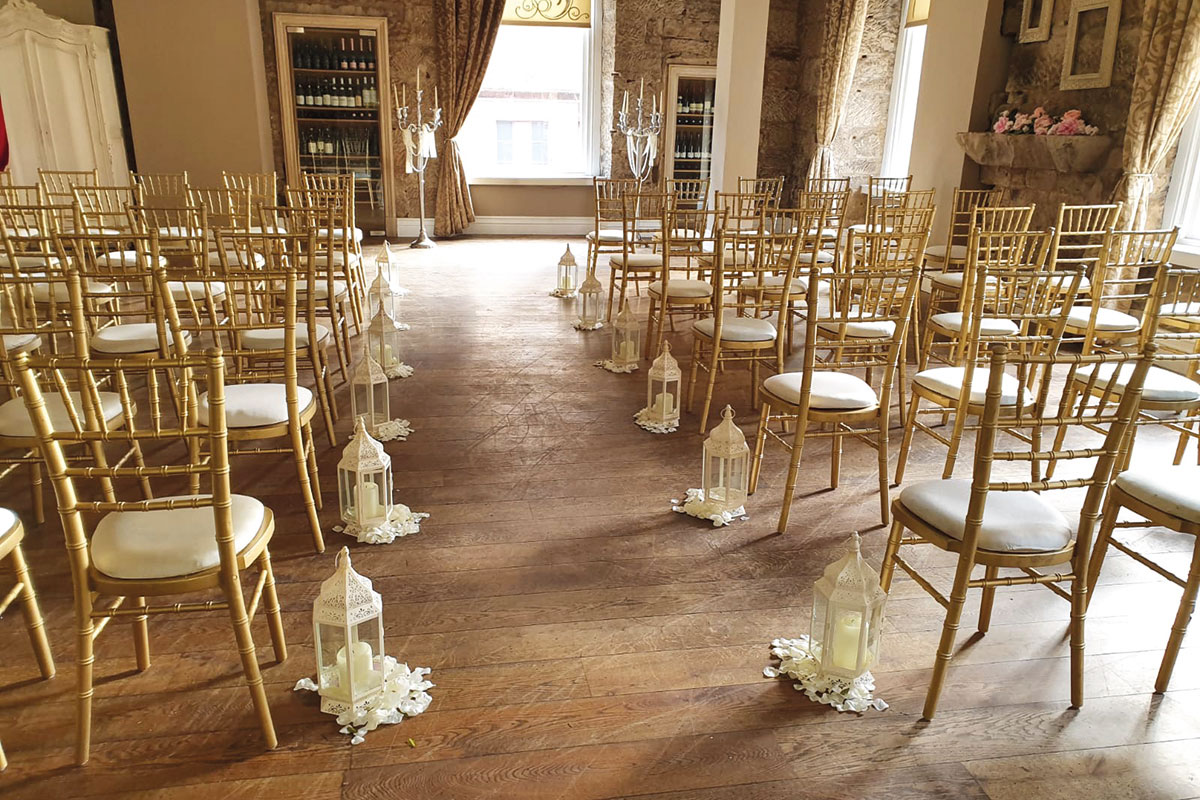 Elegant wedding ceremony space with gold chiavari chairs and white petal aisle in Glasgow.