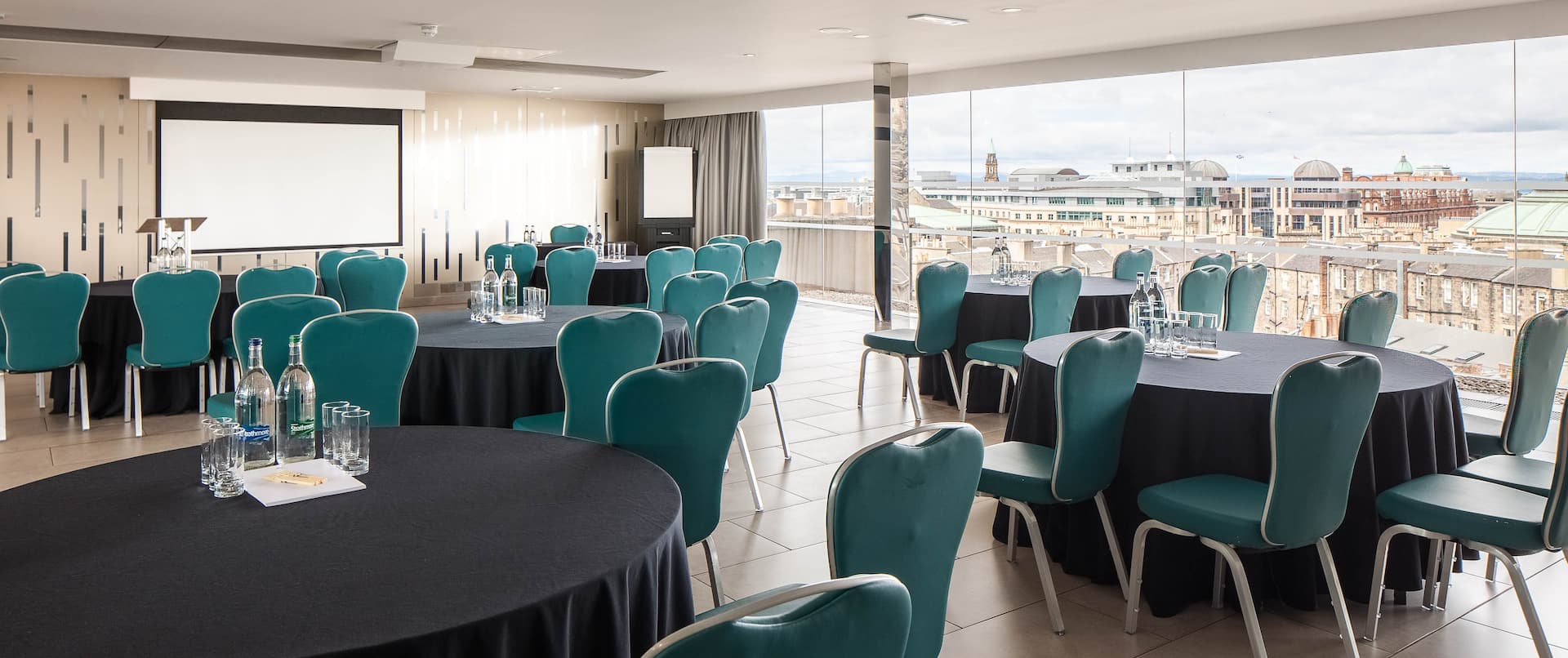 Meeting room with teal chairs and natural light at DoubleTree by Hilton Edinburgh for corporate events.